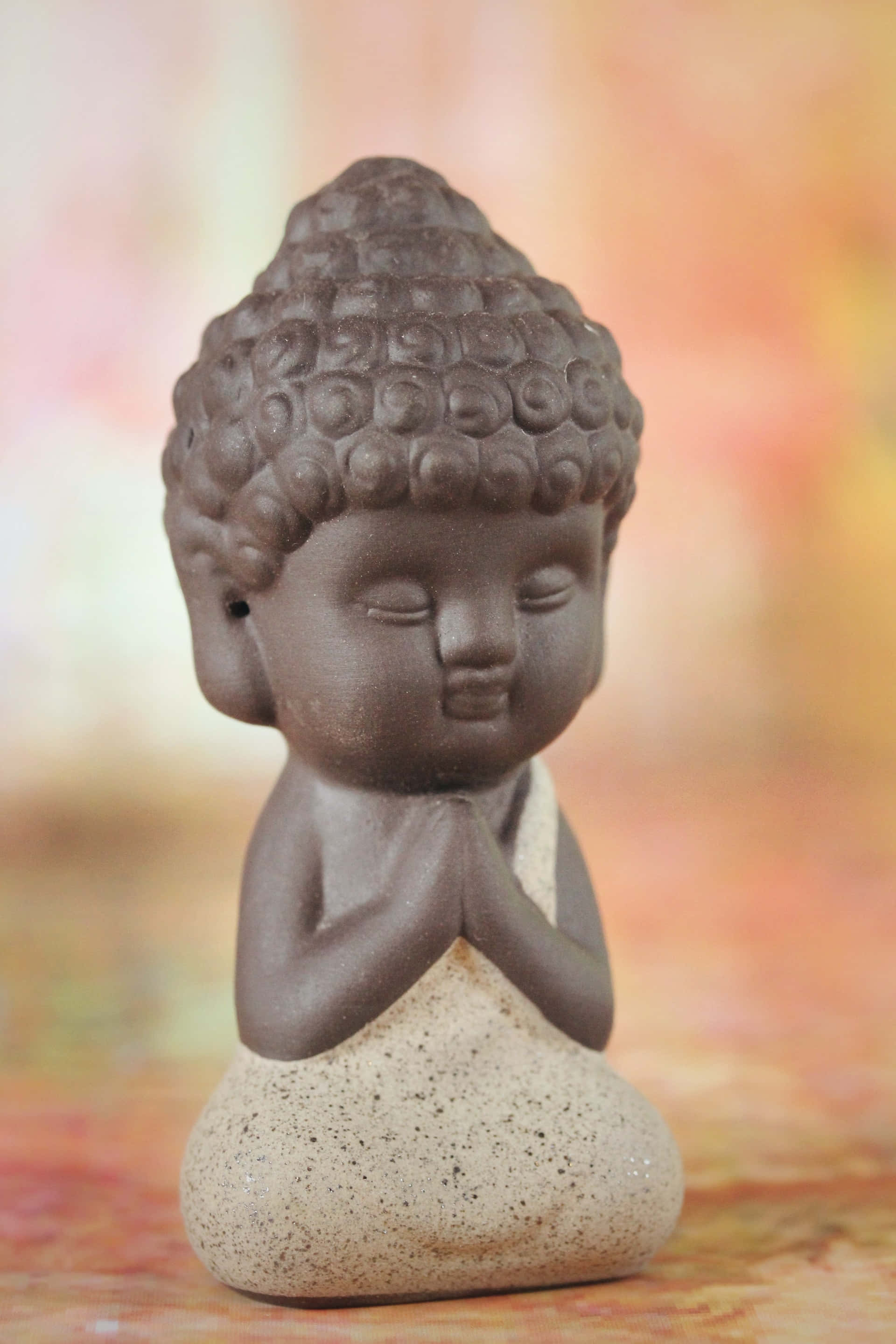 brown Buddha figurine, closed eyes, clasped hands, 2K Phone Wallpaper