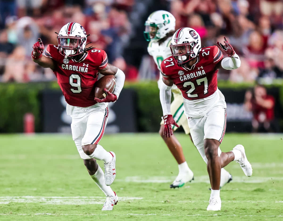 South Carolina Gamecocks, red and white uniforms, green field, SD Desktop Wallpaper