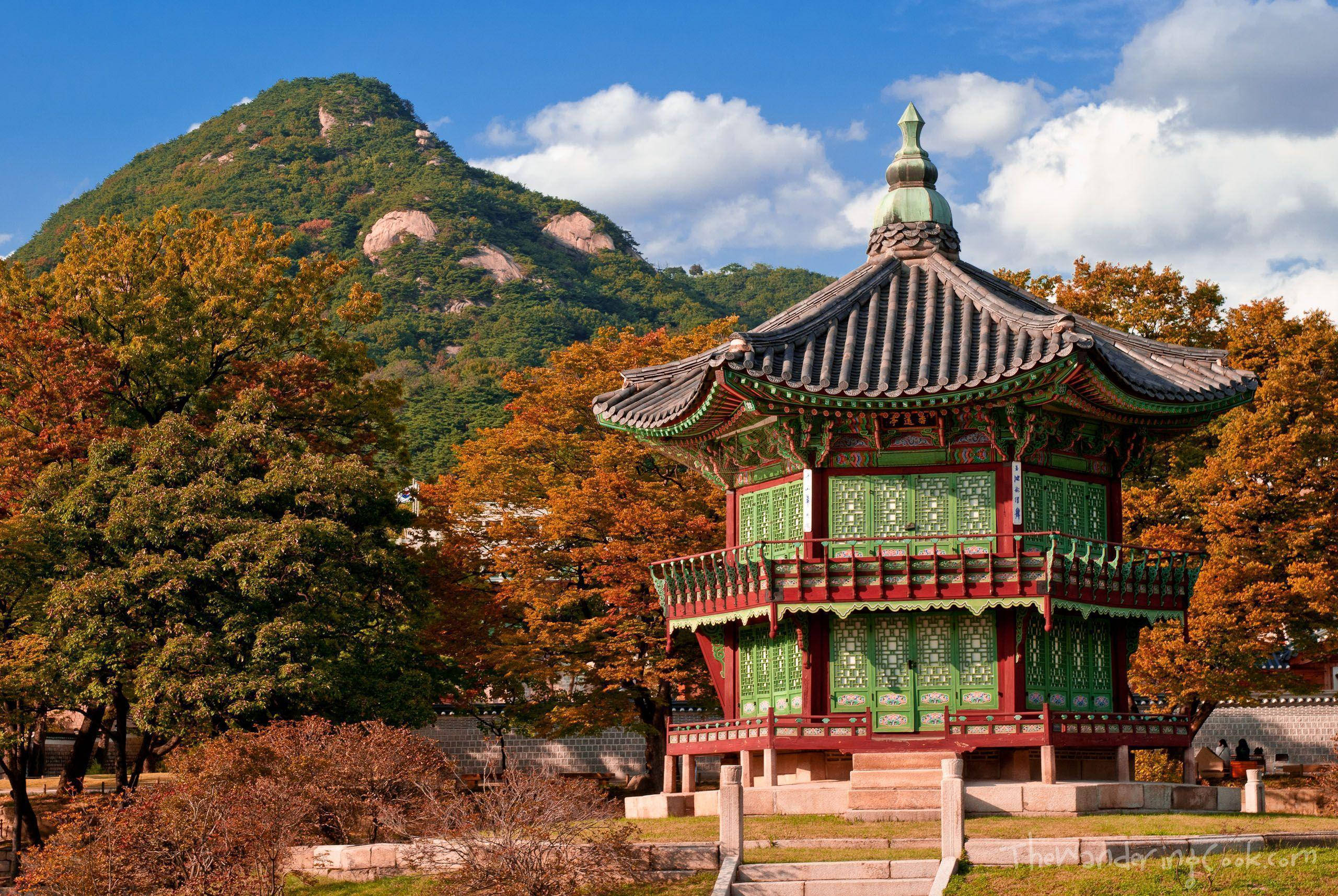 traditional Korean pavilion, green and red accents, autumn trees, 2K Desktop Wallpaper