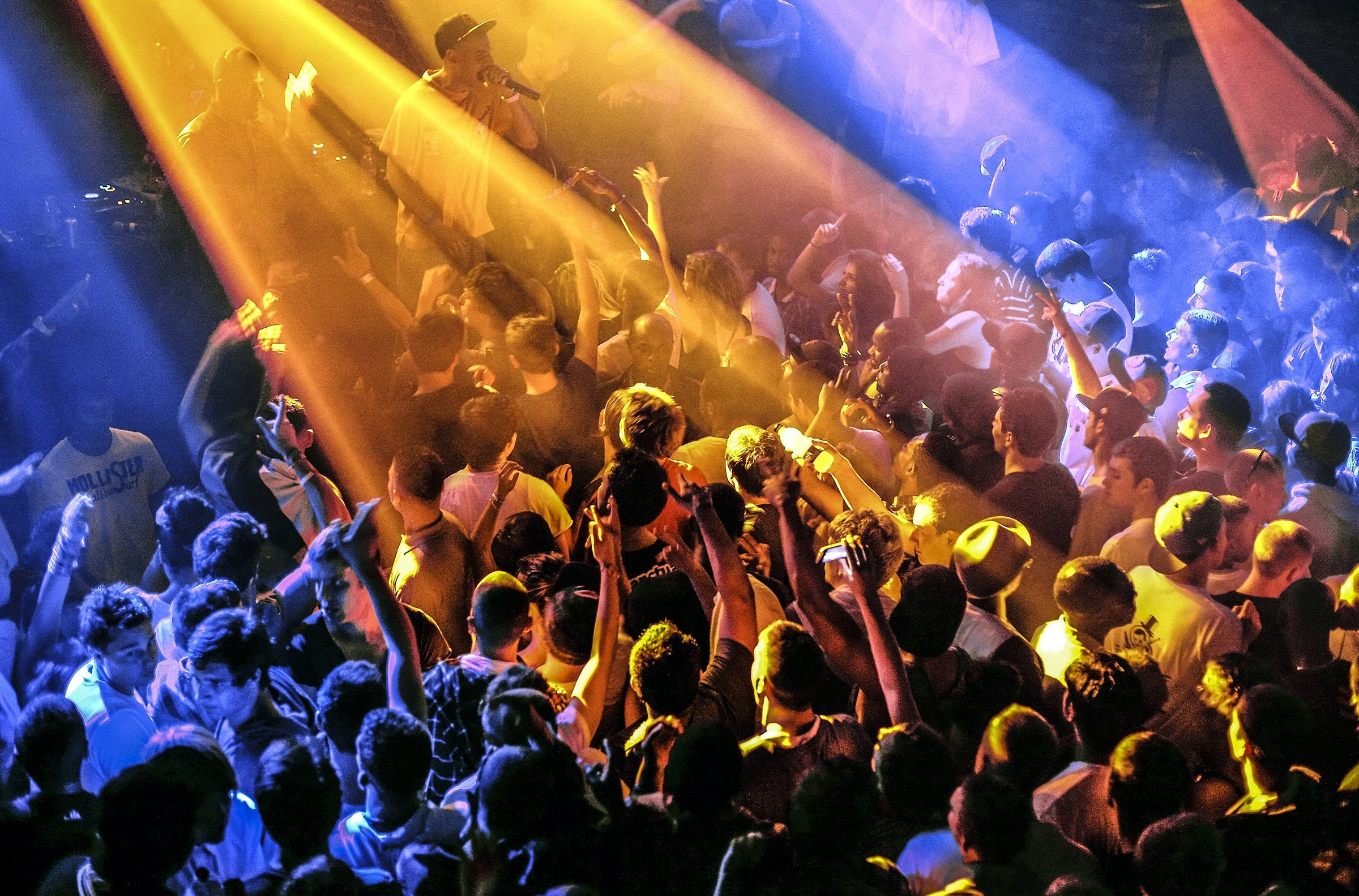 vibrant yellow and blue stage lights, high-energy concert, crowd surges, Full HD Desktop Wallpaper