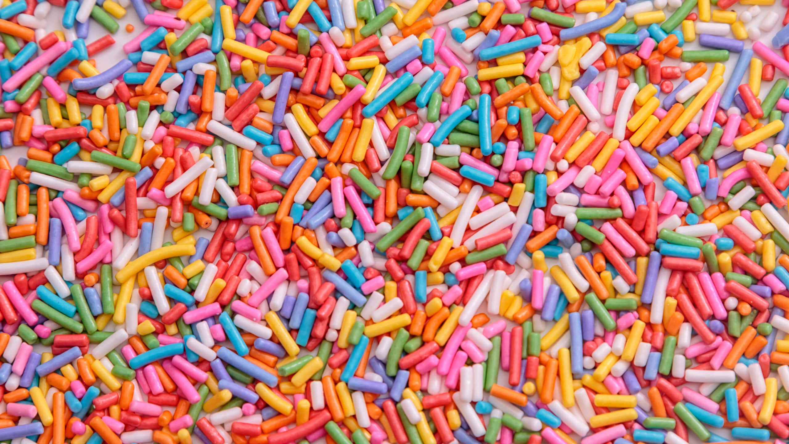 colorful sprinkles, assorted colorful candy sprinkles, white surface, 2K Desktop Wallpaper
