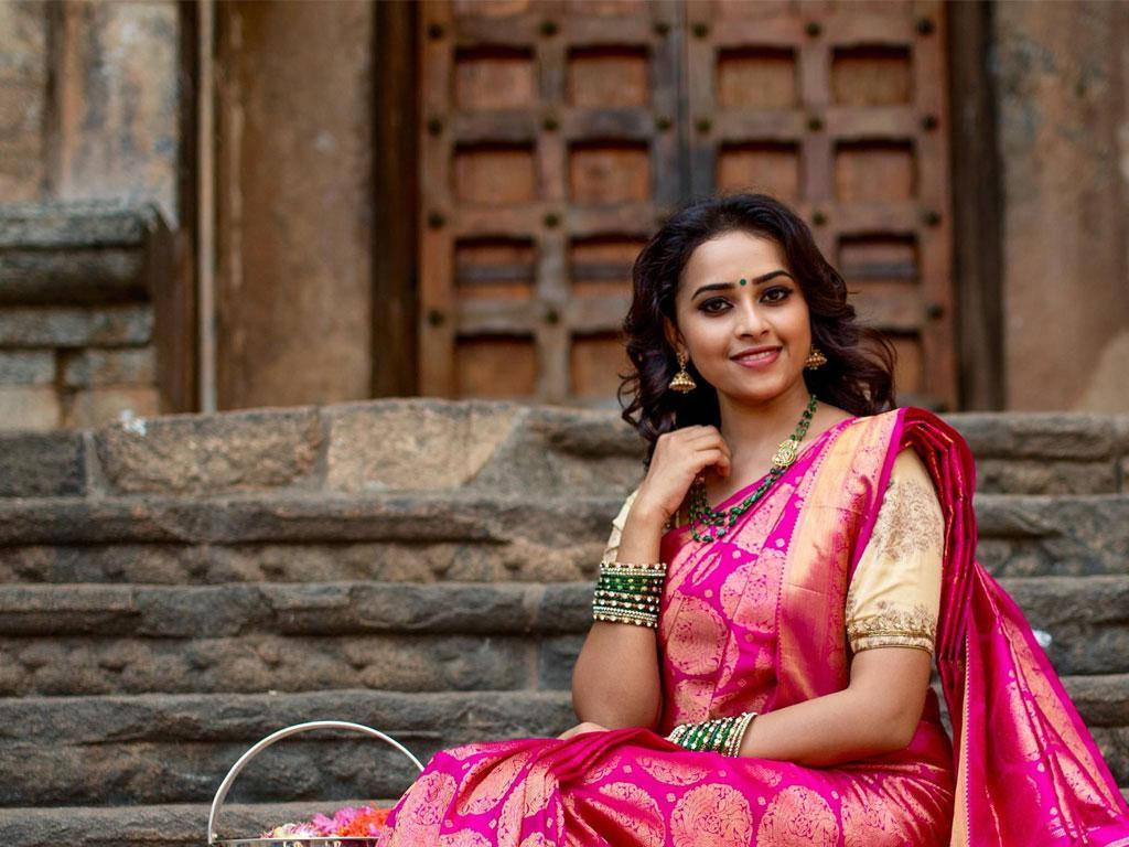 Sri Divya, vibrant pink and gold saree, ancient stone steps, SD Desktop Wallpaper