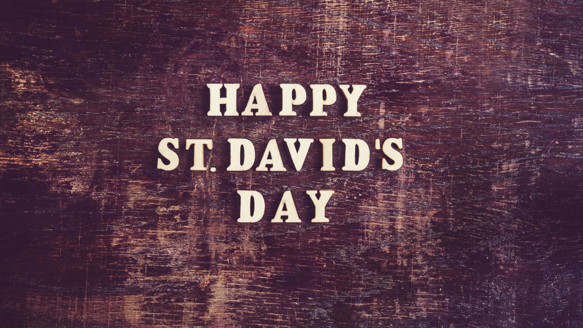 HAPPY ST. DAVID'S DAY, cream-colored block letters, textured dark wood background, Full HD Desktop Wallpaper
