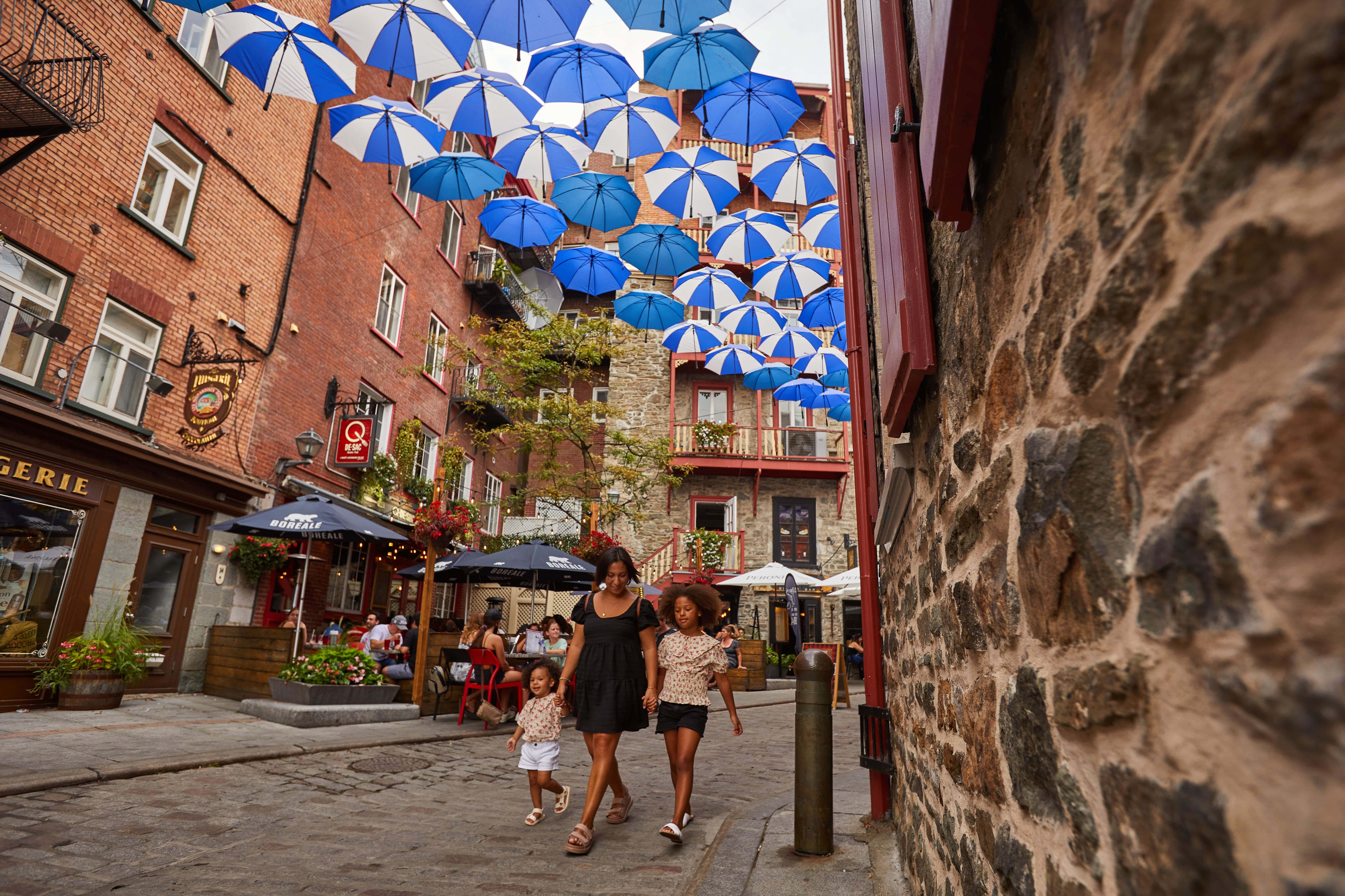 St Jean Baptiste Day, cobblestone alleyway, blue and white umbrellas, 5K Desktop Wallpaper