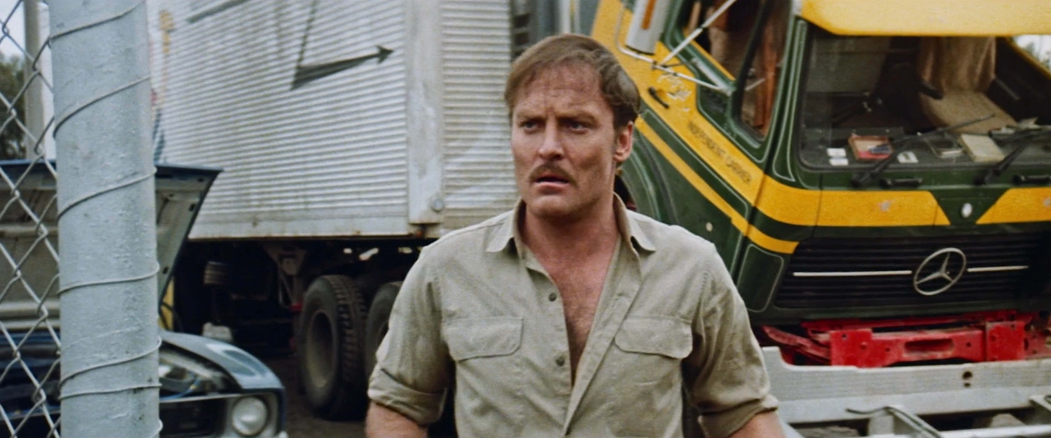 Stacy Keach, green and yellow Mercedes truck, chain-link fence, 2K Desktop Wallpaper