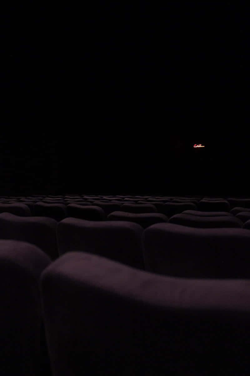 dark theater seats, black screen, glowing red exit sign, SD Phone Wallpaper