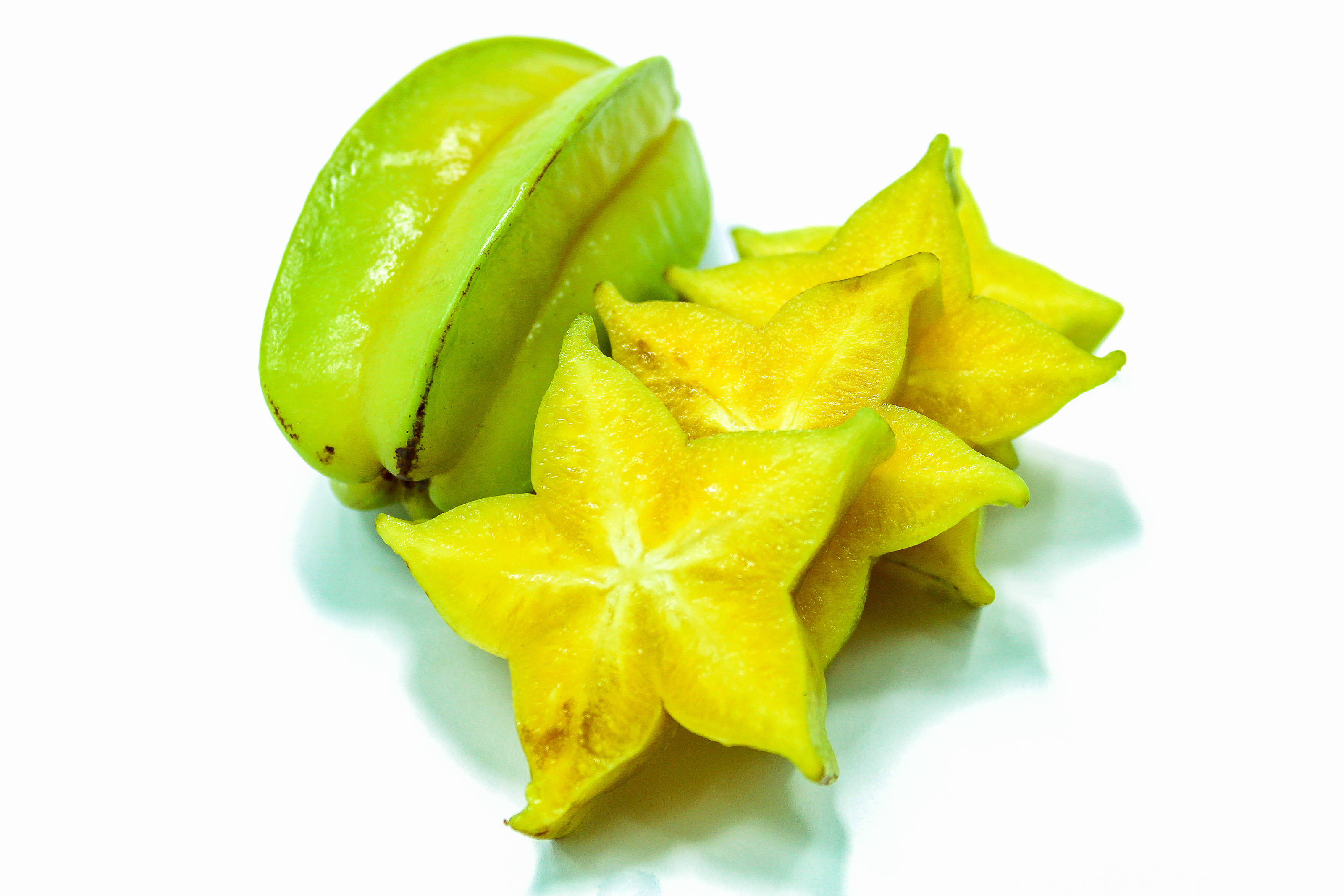 Star Fruit, white surface, vibrant green, 2K Desktop Wallpaper