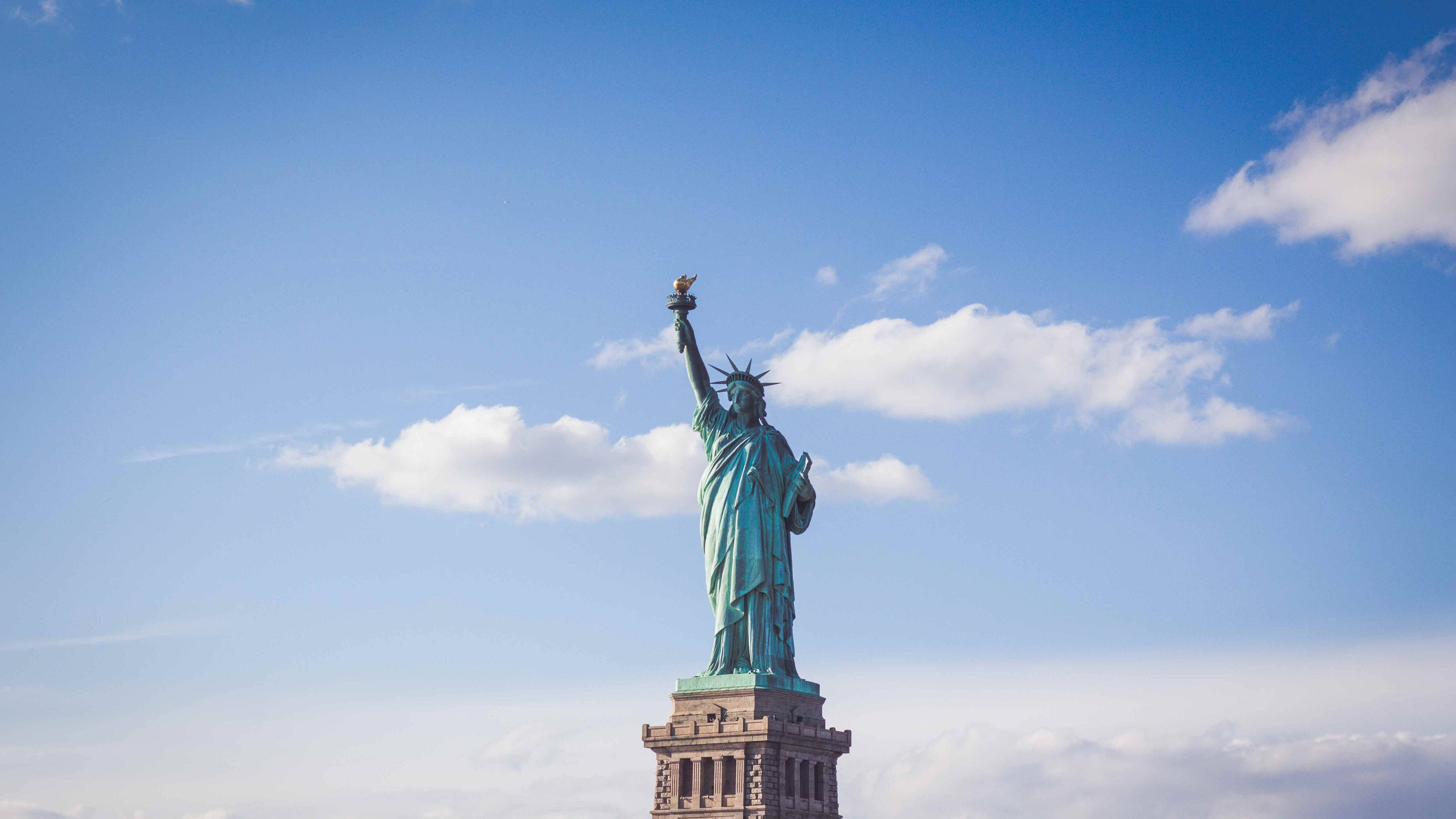 Statue Of Liberty, bright blue sky, scattered white clouds, 5K Desktop Wallpaper