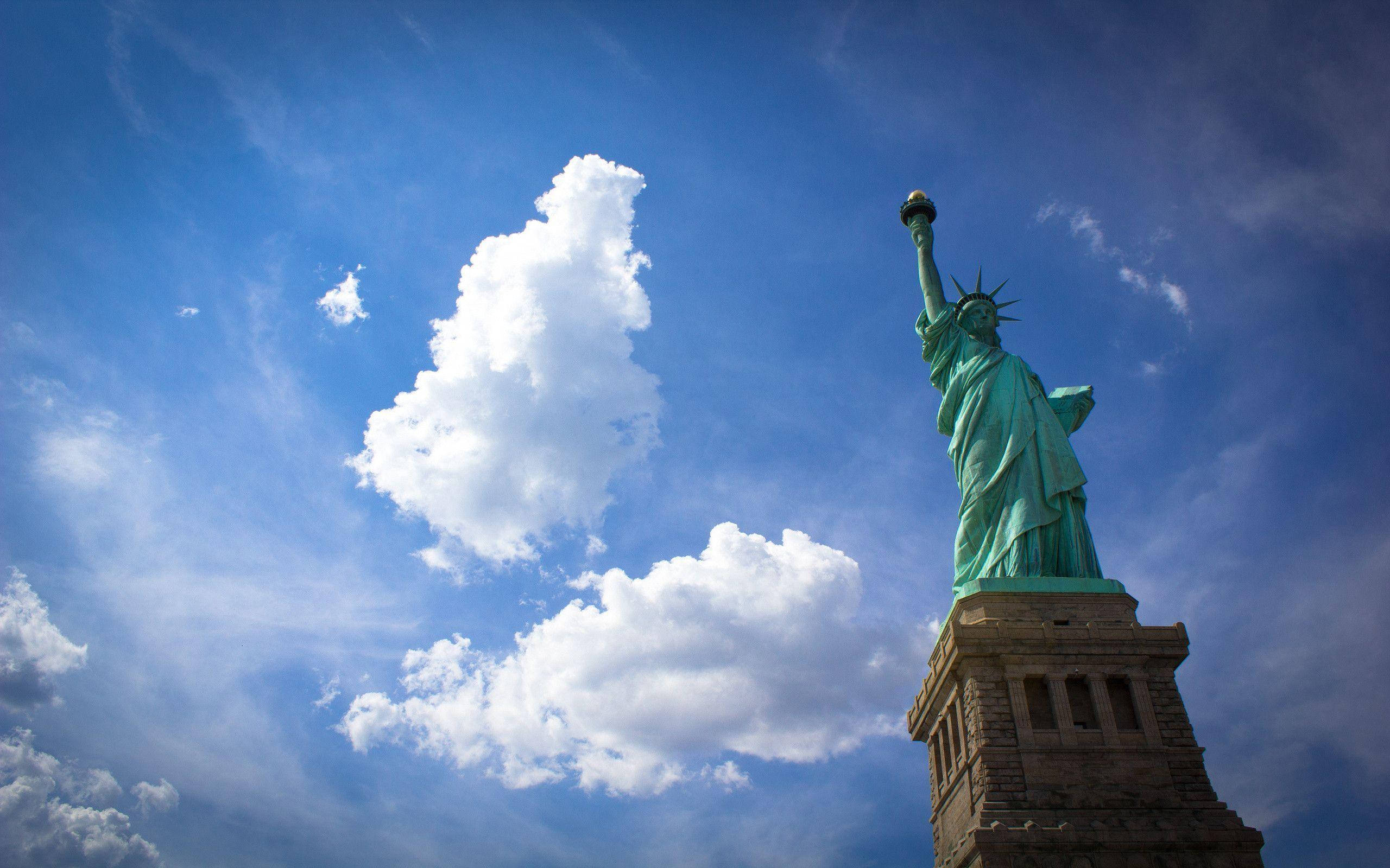 Statue Of Liberty, vibrant blue sky, fluffy white clouds, 2K Desktop Wallpaper