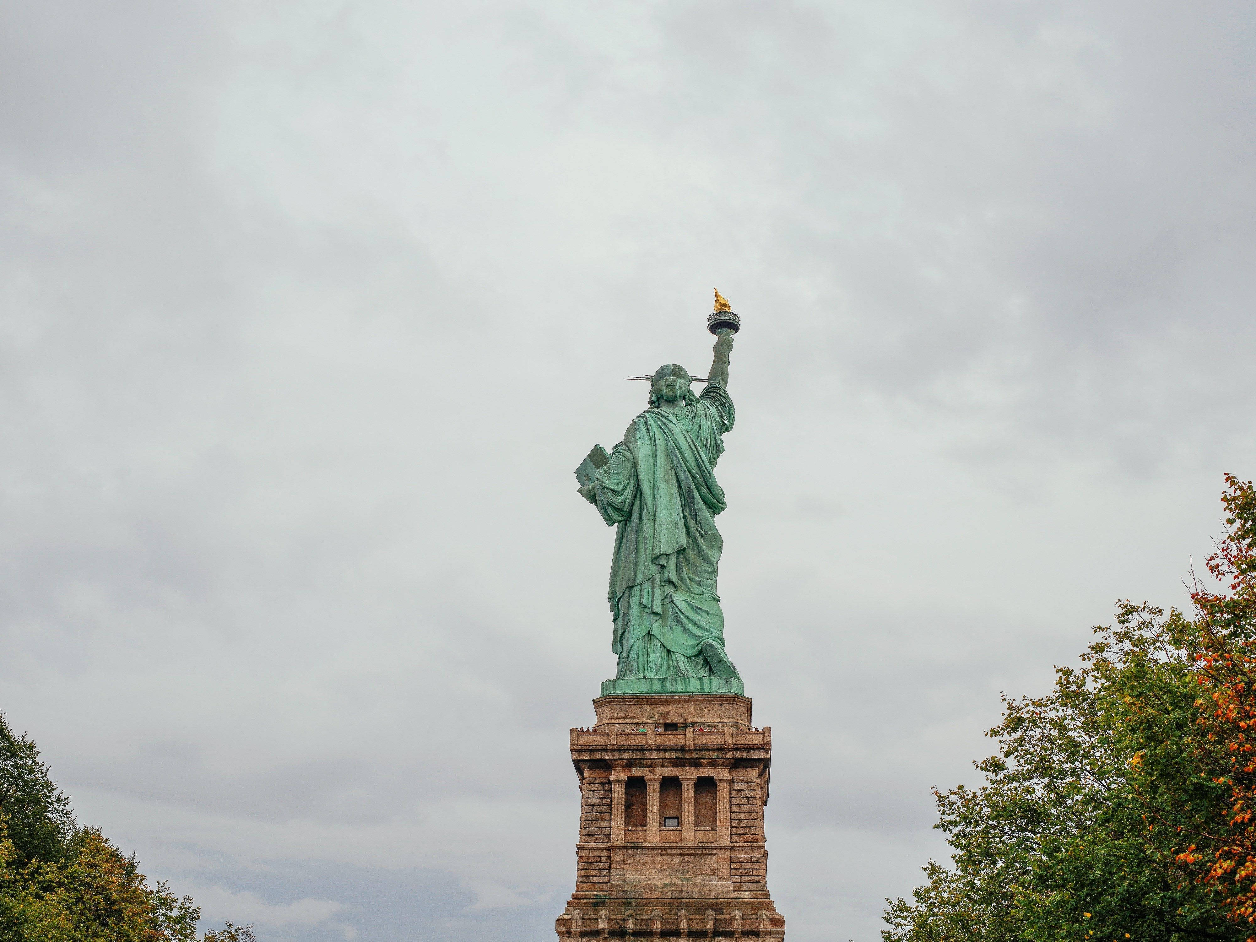 Statue Of Liberty, cloudy sky, autumn trees, 4K Desktop Wallpaper