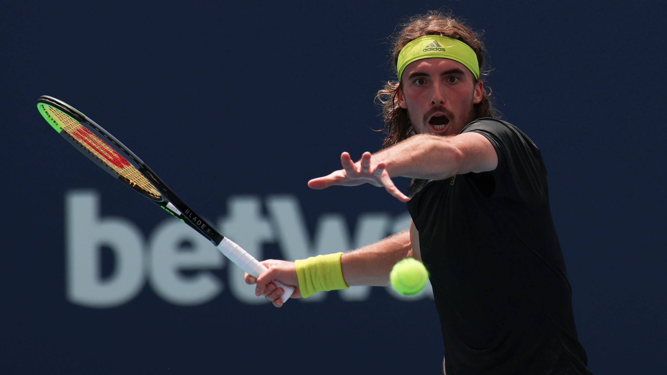 Stefanos Tsitsipas, black and neon green gear, bright yellow ball, 2K Desktop Wallpaper