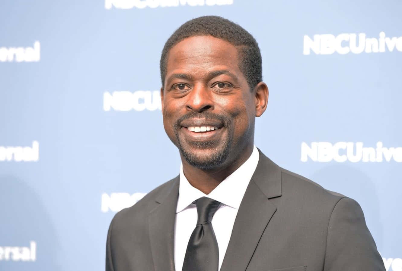 Sterling K Brown, dark suit and tie, blue NBCUniversal branded backdrop, HD Desktop Wallpaper