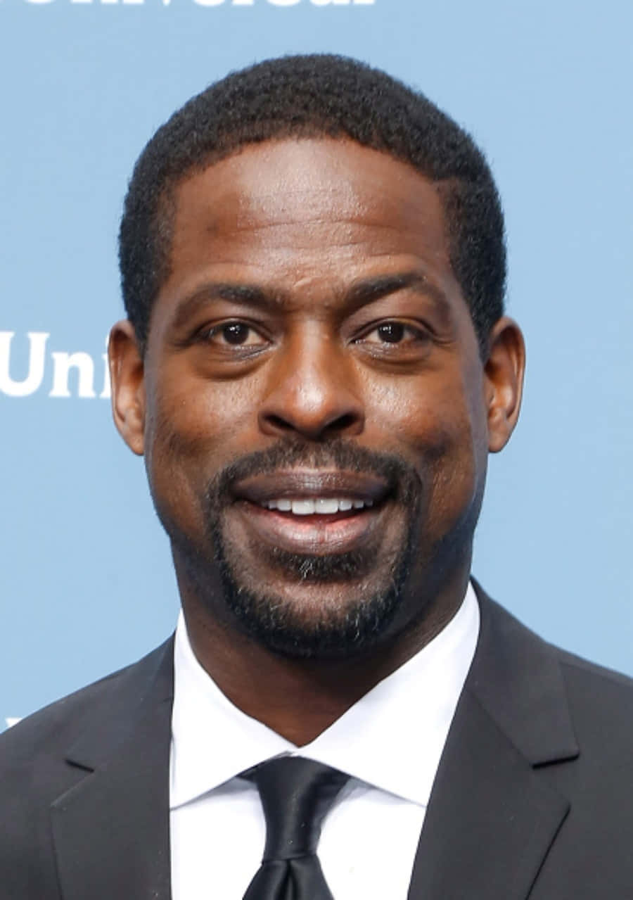Sterling K Brown, black suit and tie, light blue backdrop, SD Phone Wallpaper