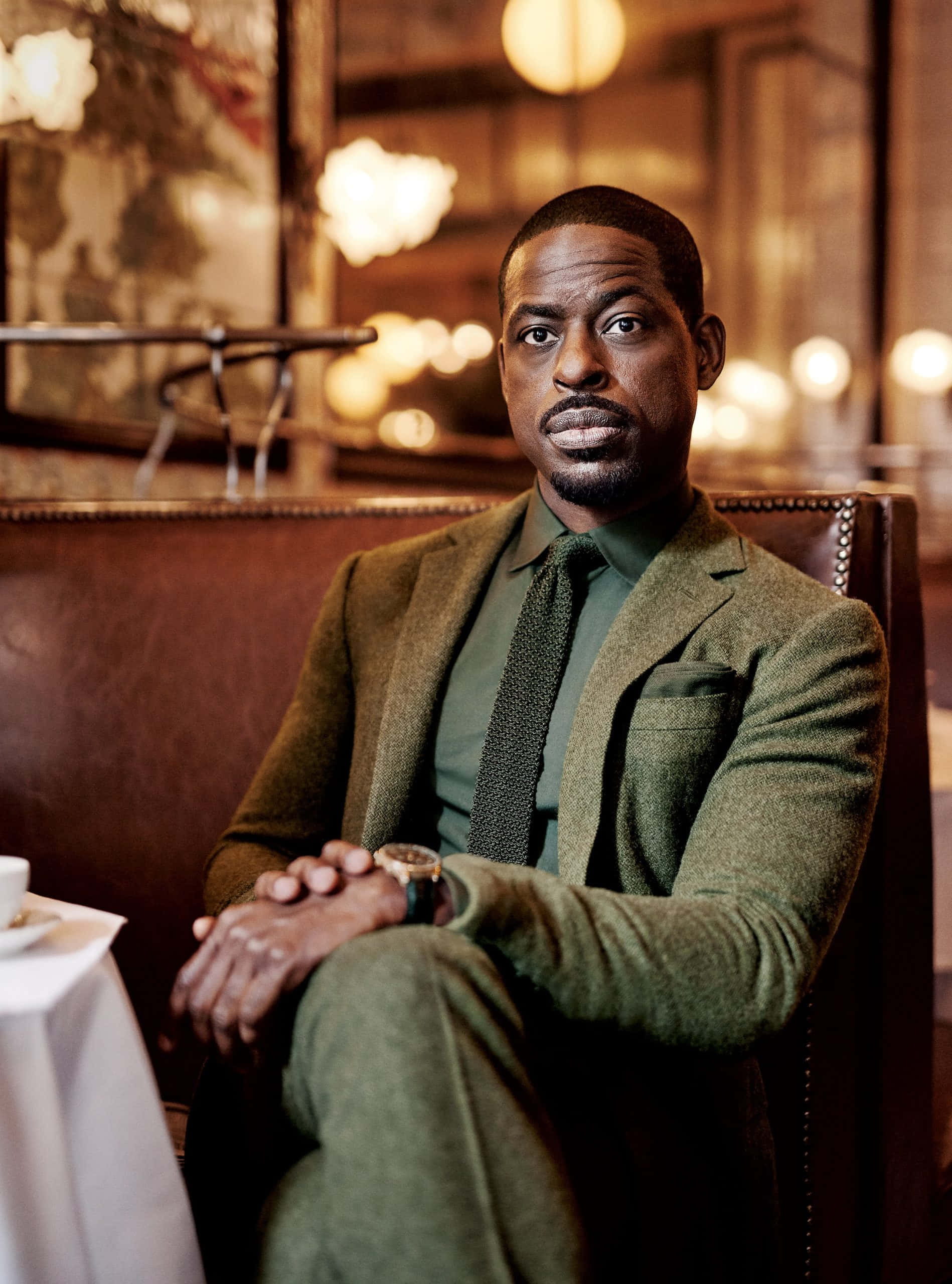 Sterling K Brown, green suit, warmly lit restaurant booth, 2K Phone Wallpaper