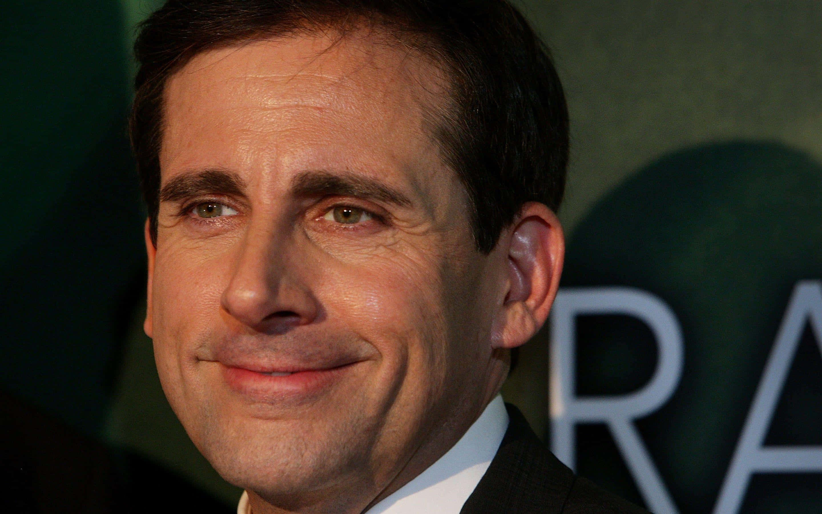 Steve Carell, dark suit, blurred green backdrop, 2K Desktop Wallpaper