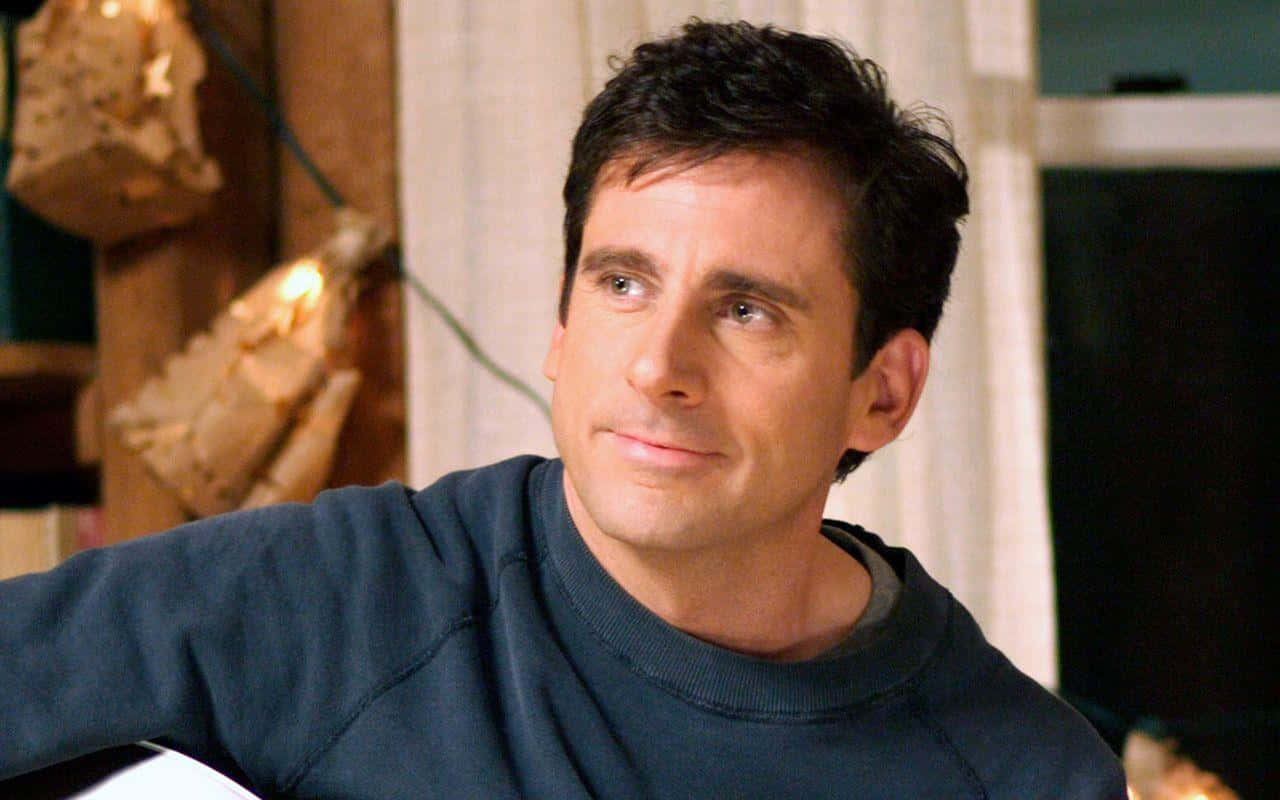 Steve Carell, dark blue sweatshirt, warmly lit indoor setting, HD Desktop Wallpaper