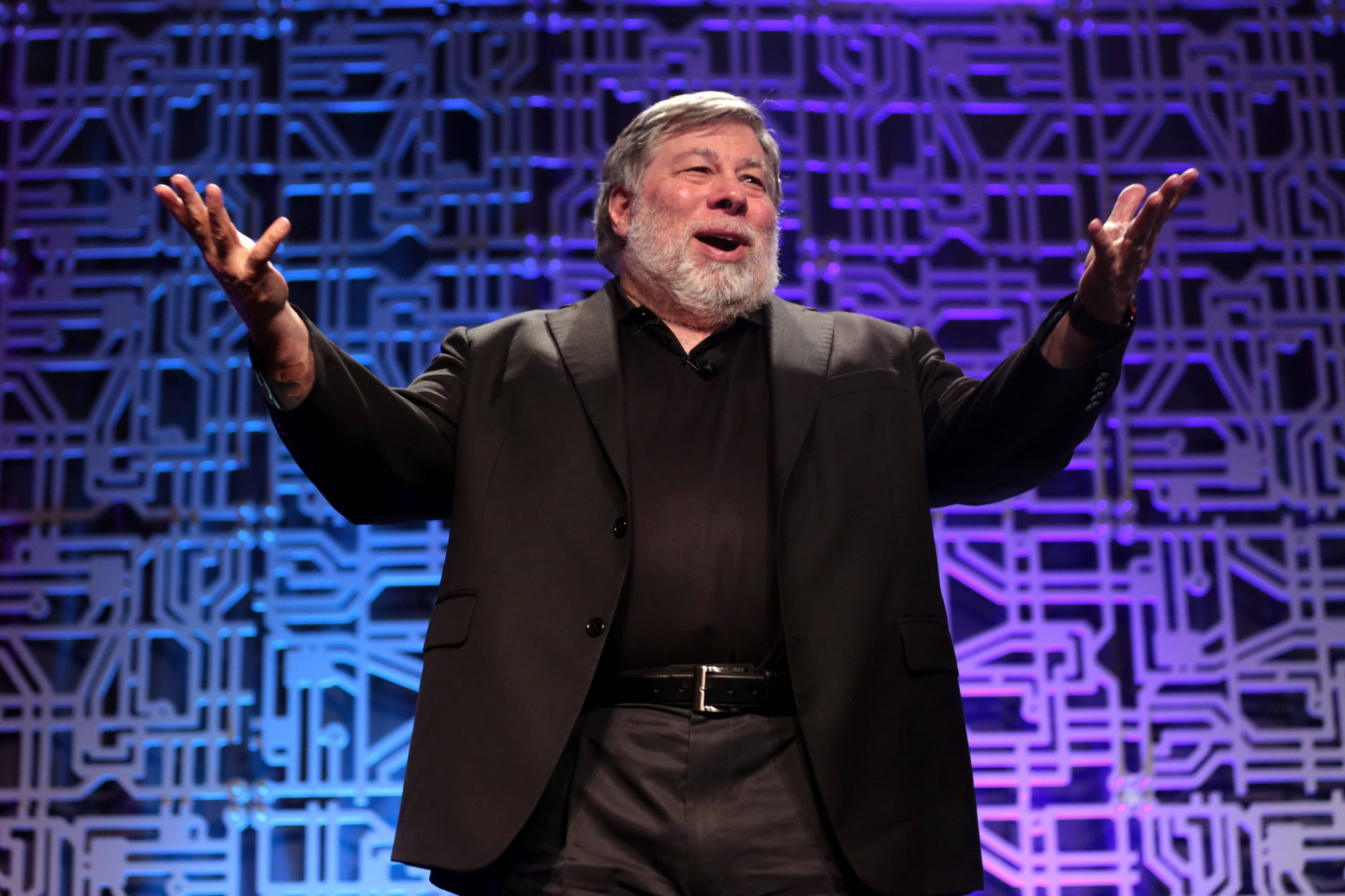 Steve Wozniak, black suit, glowing blue circuit board patterned backdrop, 4K Desktop Wallpaper