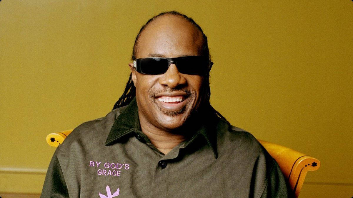 Stevie Wonder, yellow chair, mustard wall, SD Desktop Wallpaper