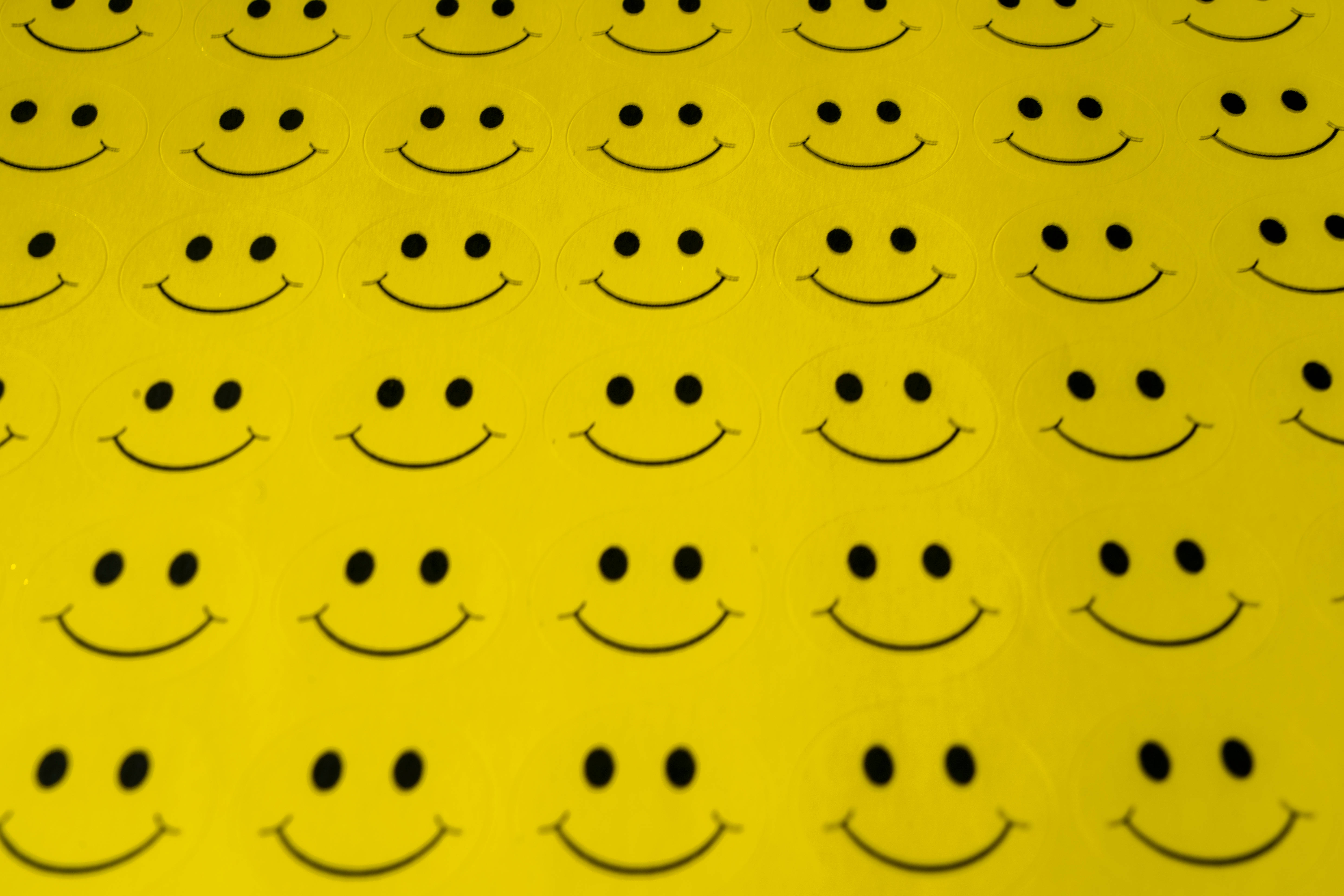 yellow smiley faces, black smiley face stickers, vibrant yellow surface, 5K Desktop Wallpaper