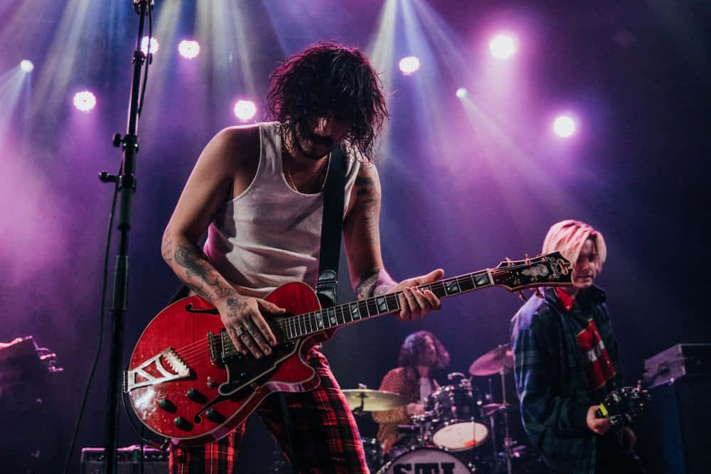 Sticky Fingers, red electric guitar, vibrant purple stage lights, SD Desktop Wallpaper