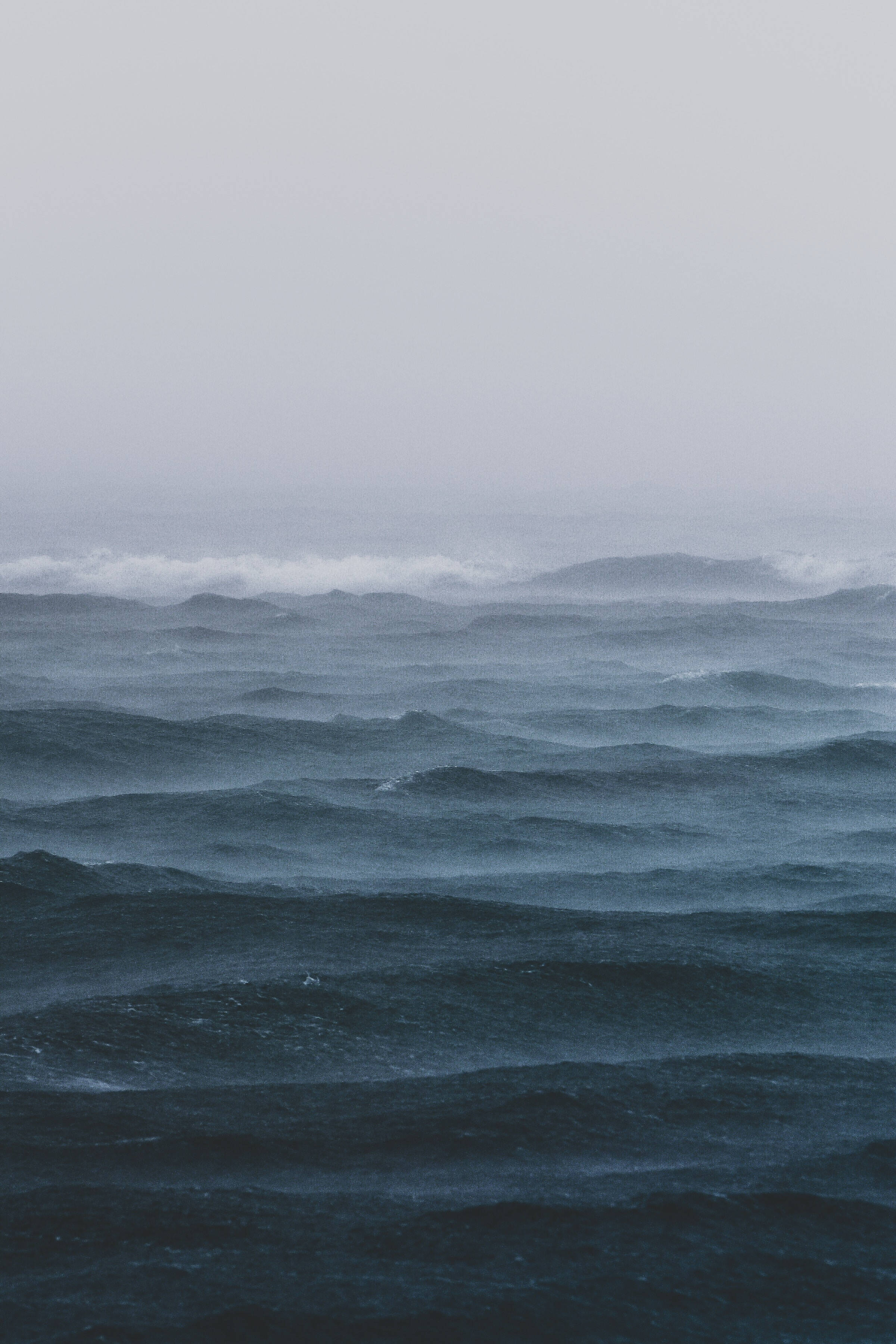 foggy sea storm waves, churning dark blue waves, overcast gray sky, 2K Phone Wallpaper