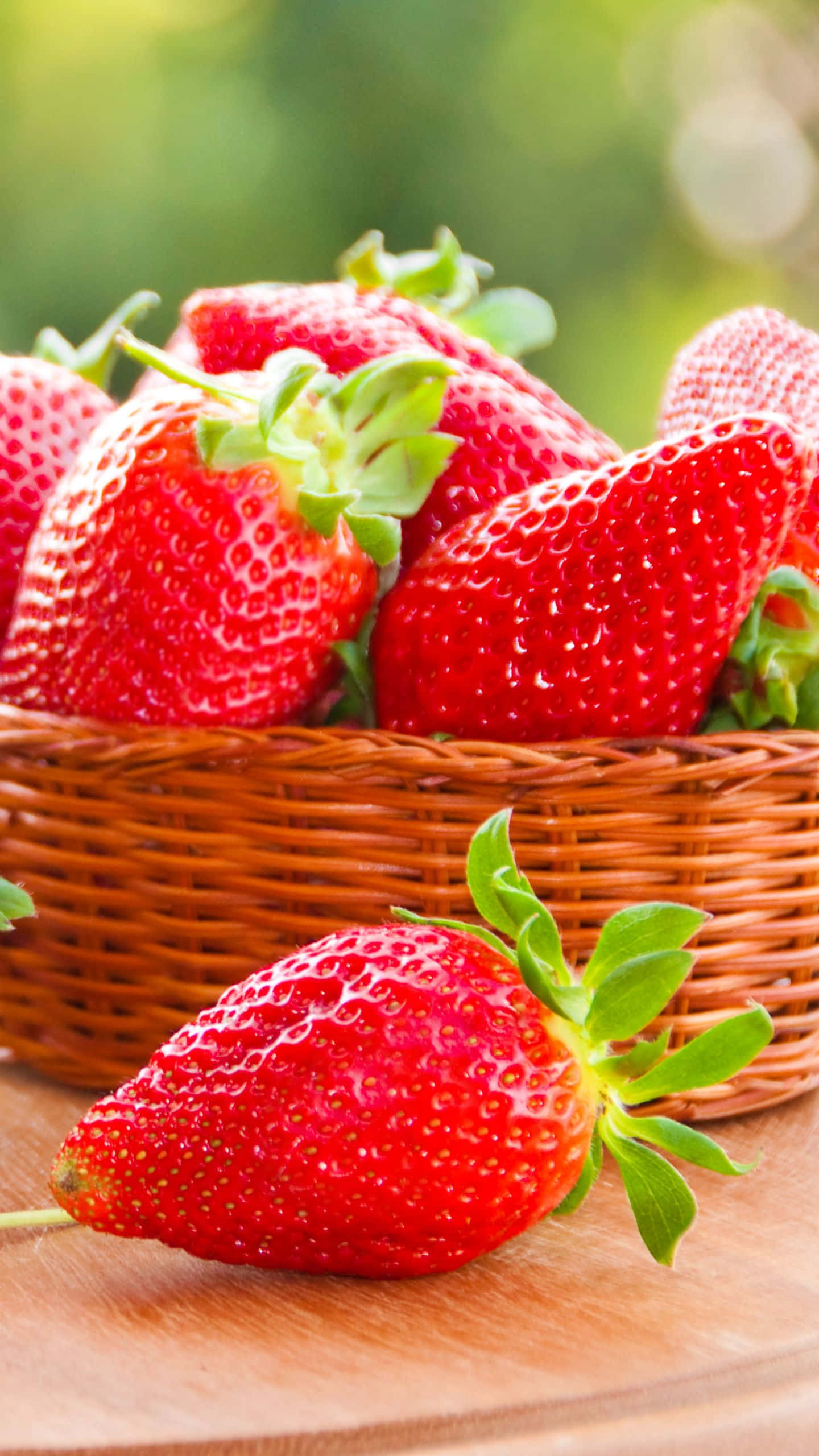 red strawberry, woven basket, wooden surface, 2K Phone Wallpaper