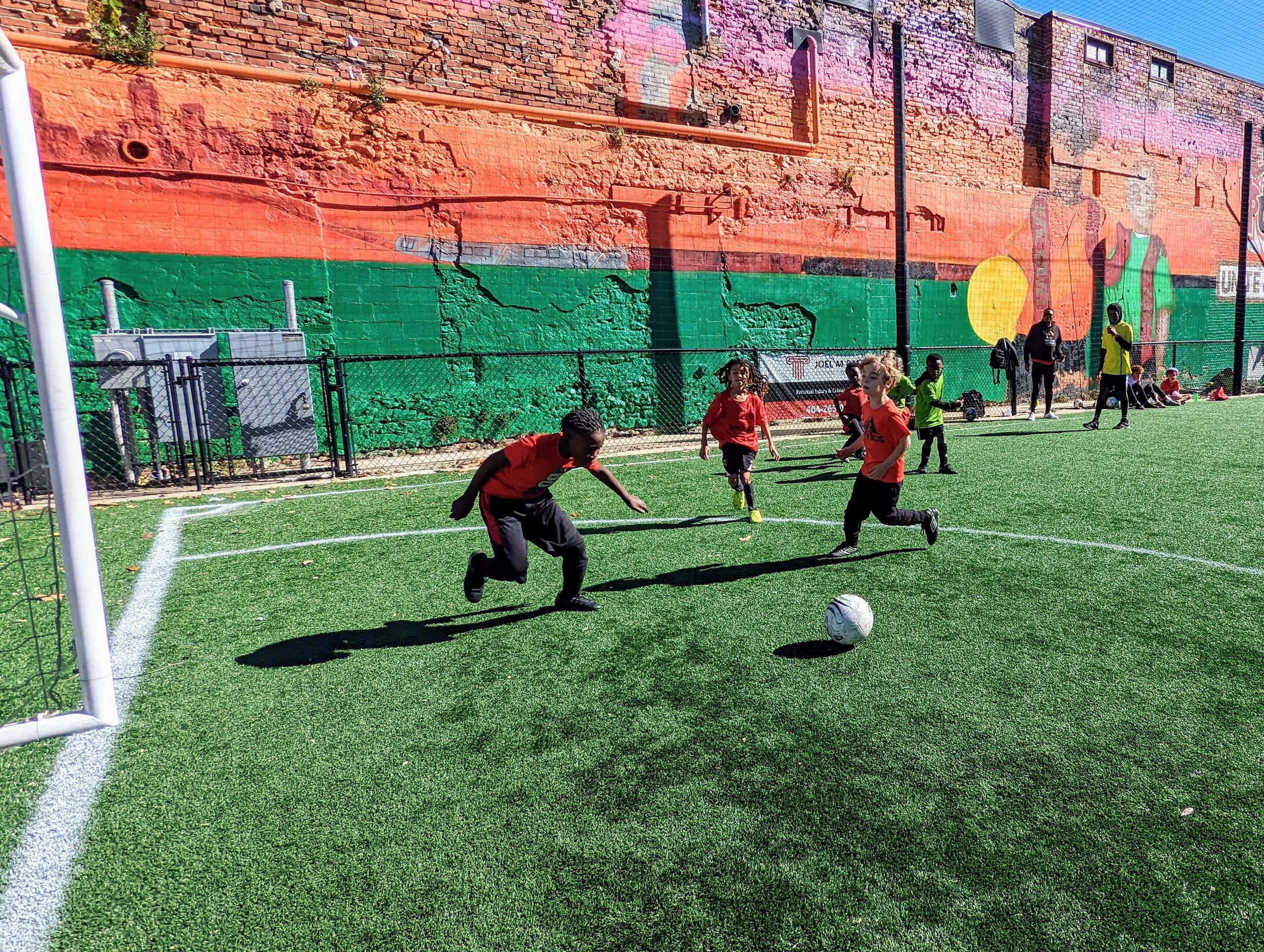 red jerseys, vibrant green turf, colorful graffiti-covered brick wall, Full HD Desktop Wallpaper