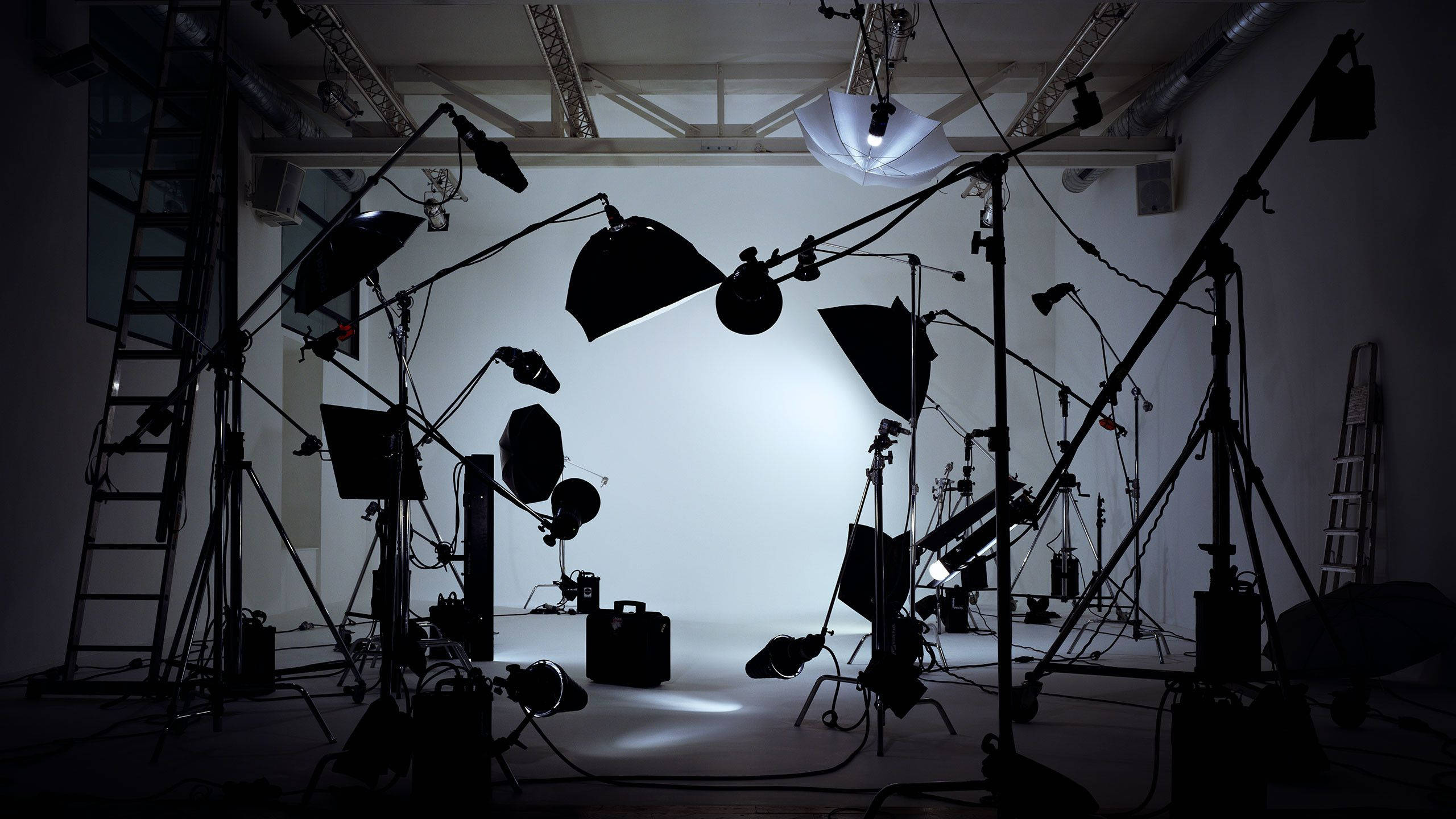 film and photography studio, dimly lit, silhouetted lighting equipment, 2K Desktop Wallpaper