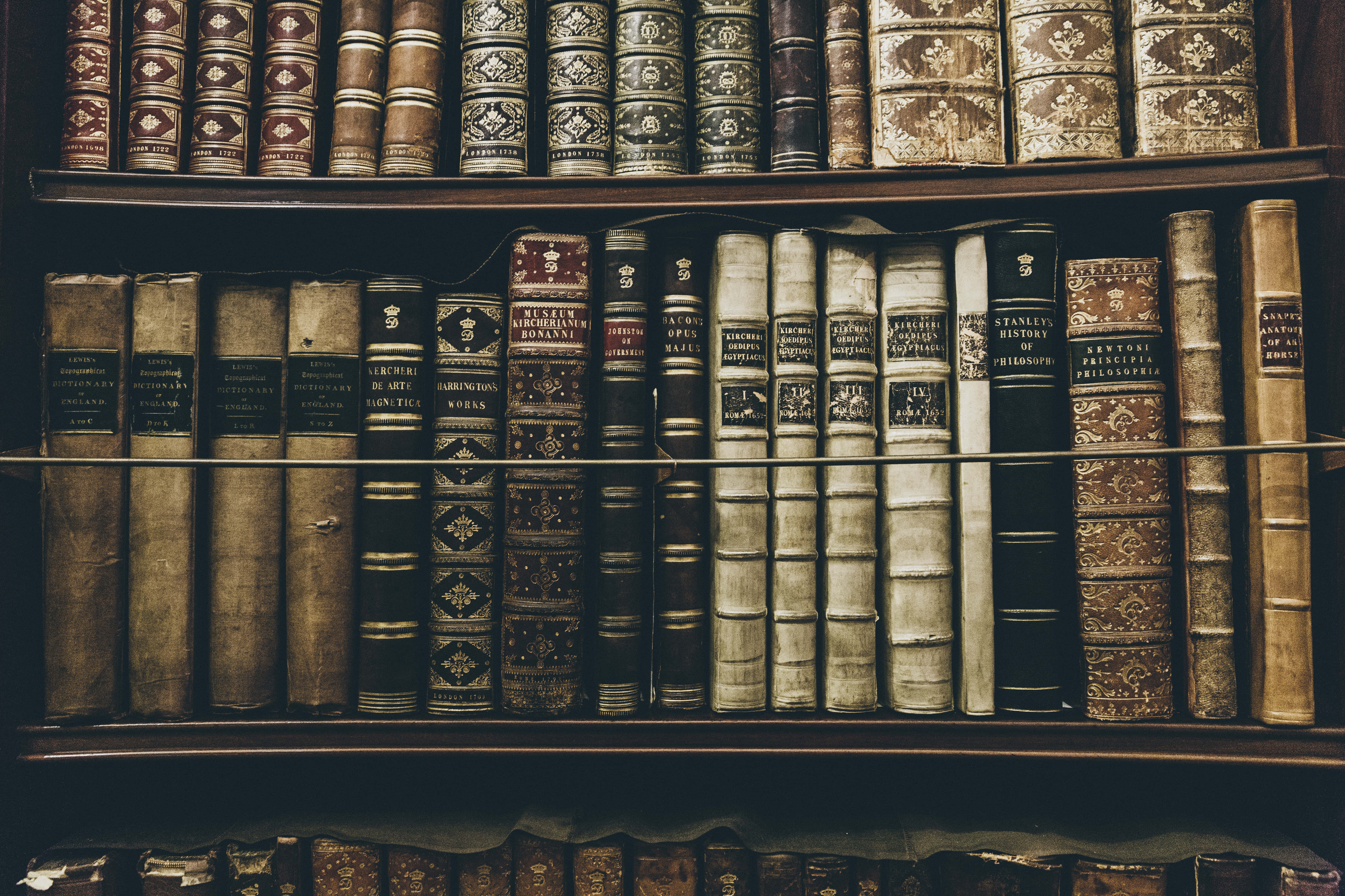 antique leather-bound books, ornate gold embossing, wooden shelves, 5K Desktop Wallpaper