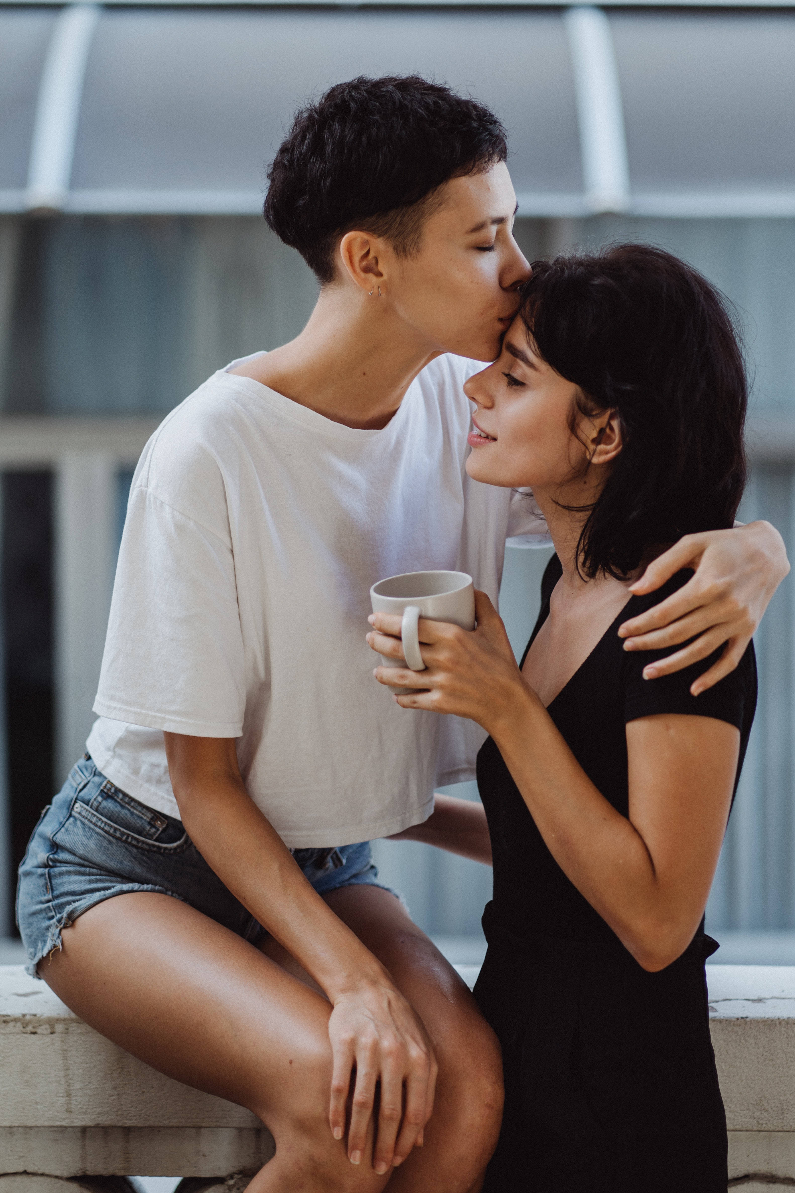 lesbian girl forehead kiss, forehead kiss, holding a mug, 4K Phone Wallpaper