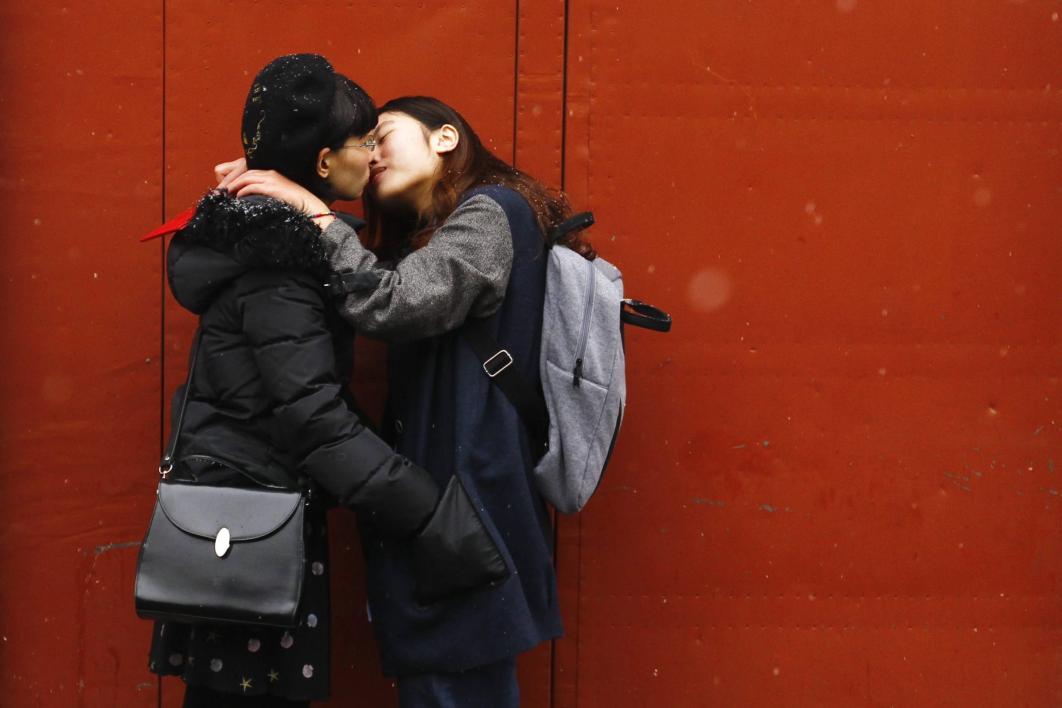 lesbian girl red kiss, vibrant red wall, snowflakes, 2K Desktop Wallpaper