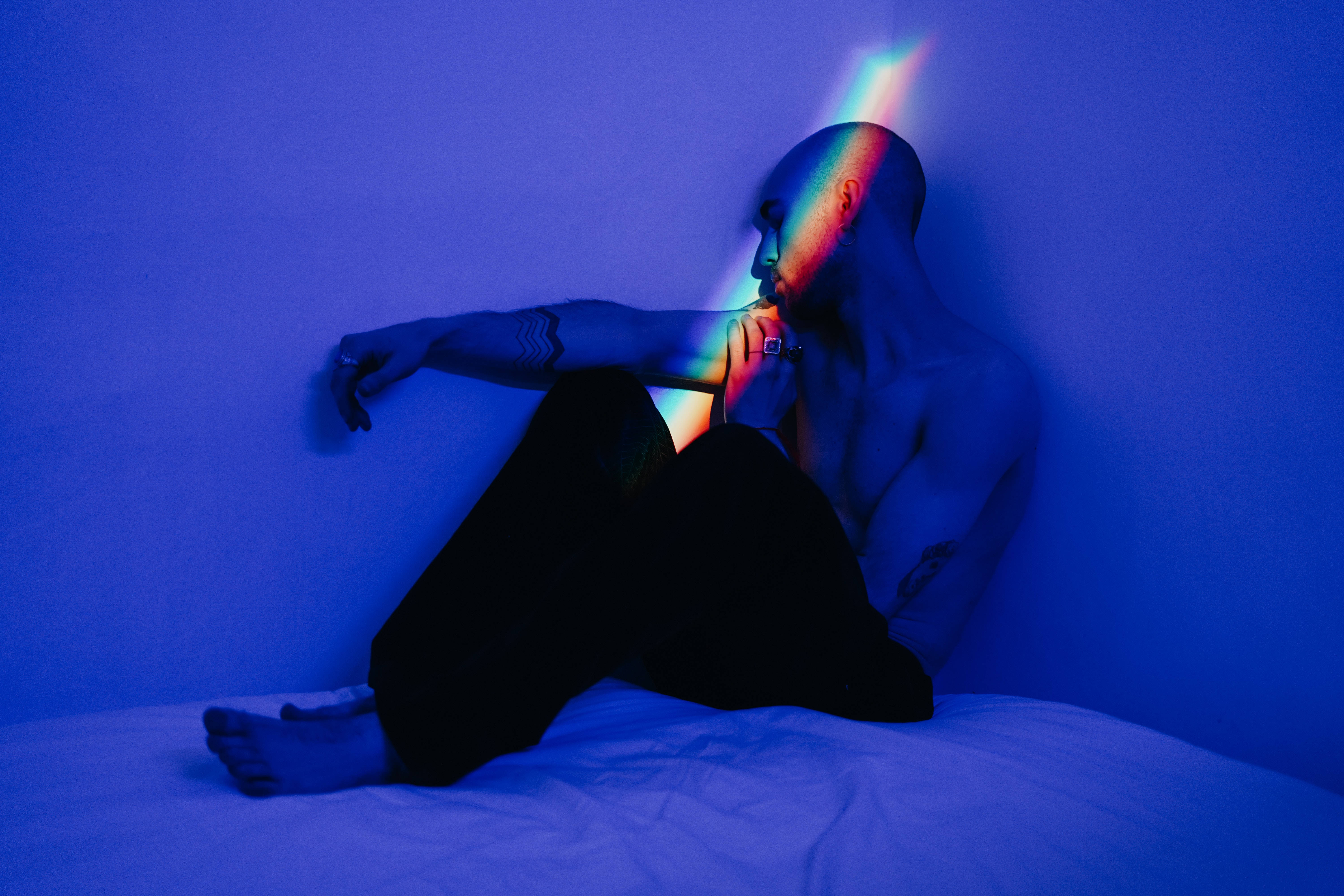 rainbow light beam, blue-lit room, shirtless man, 5K Desktop Wallpaper