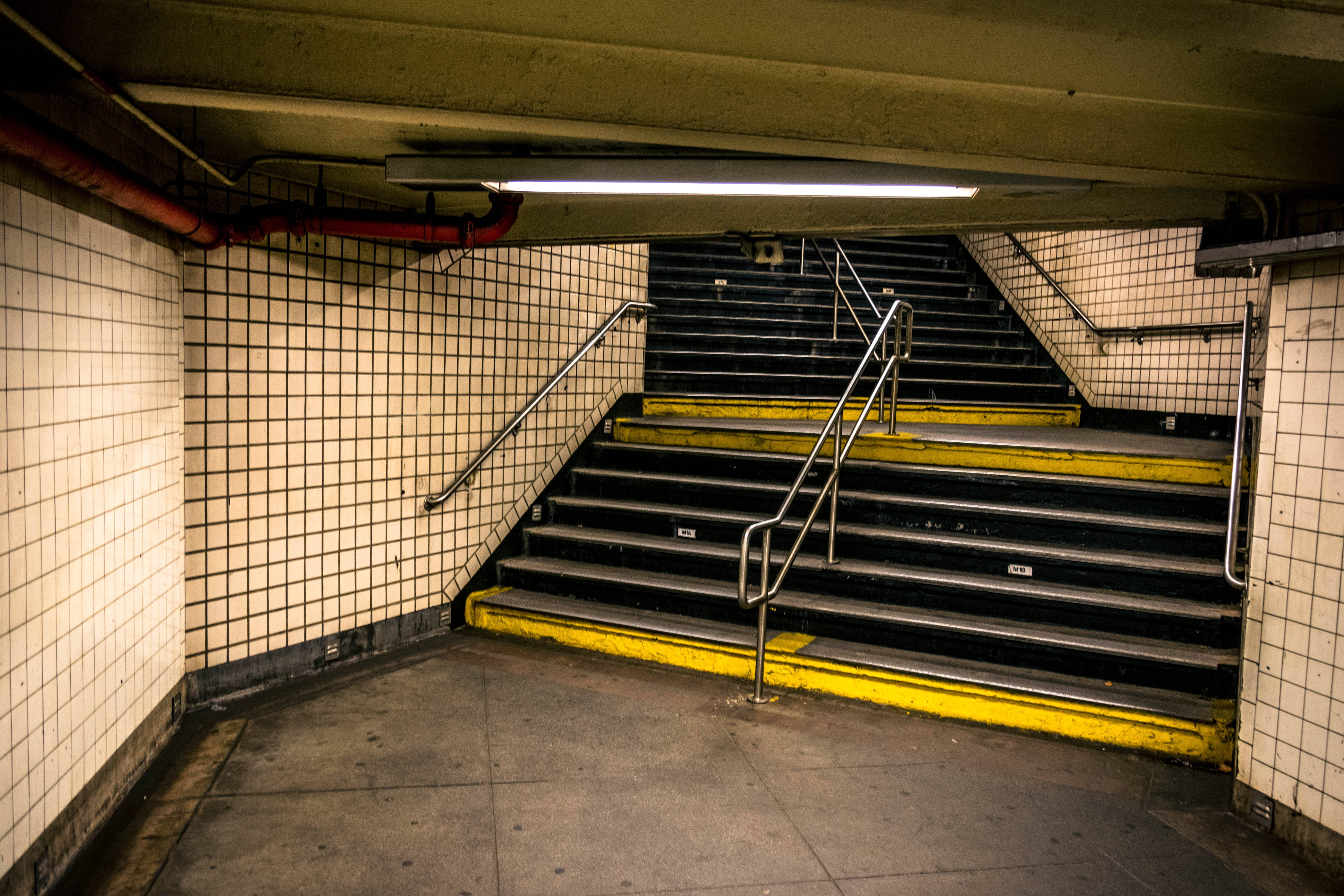 subway stairwell, yellow-painted steps, tiled walls, 5K Desktop Wallpaper