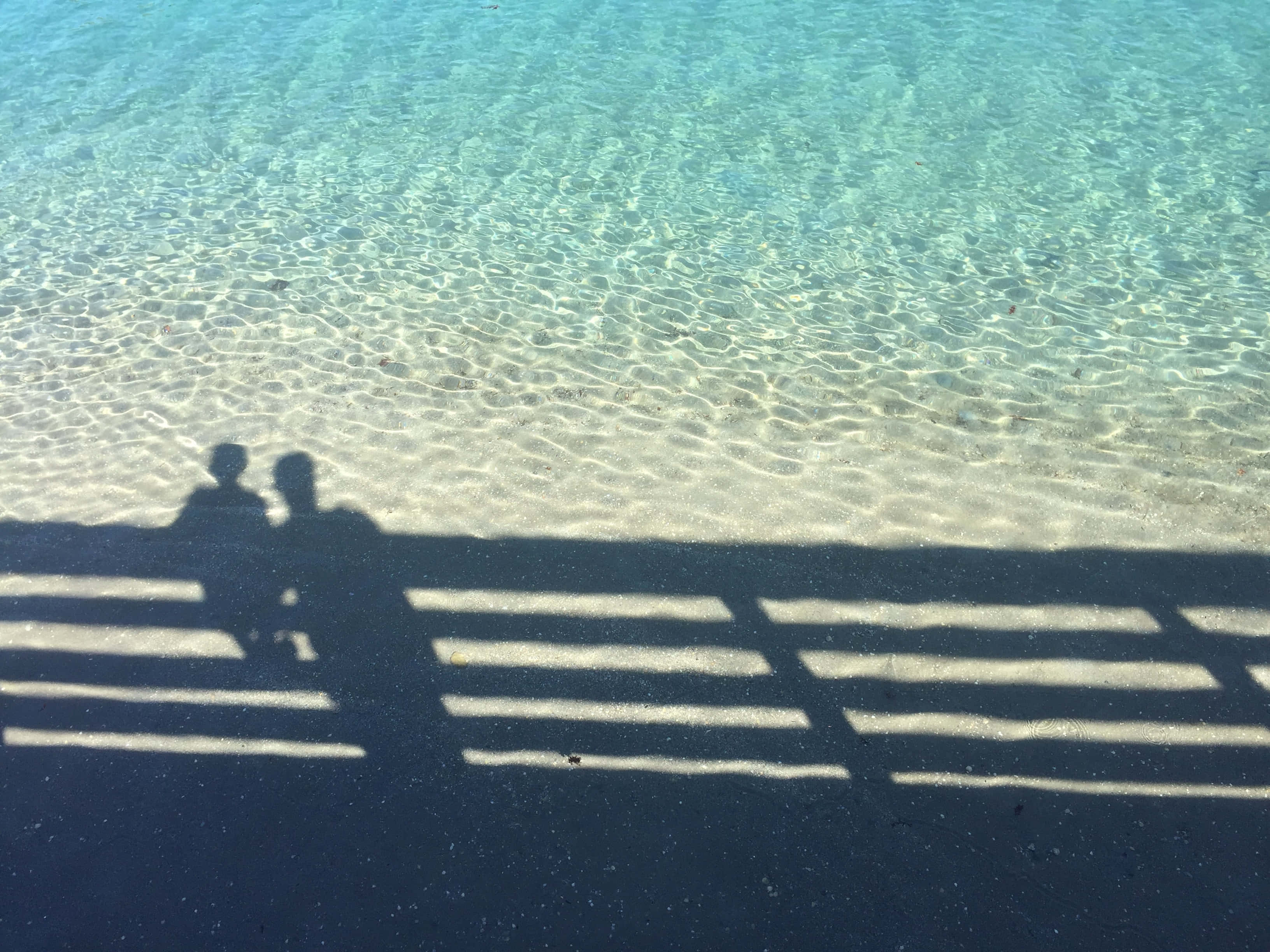 Tropical Summer Vacation Paradise, dark sand, rippling turquoise water, 2K Desktop Wallpaper