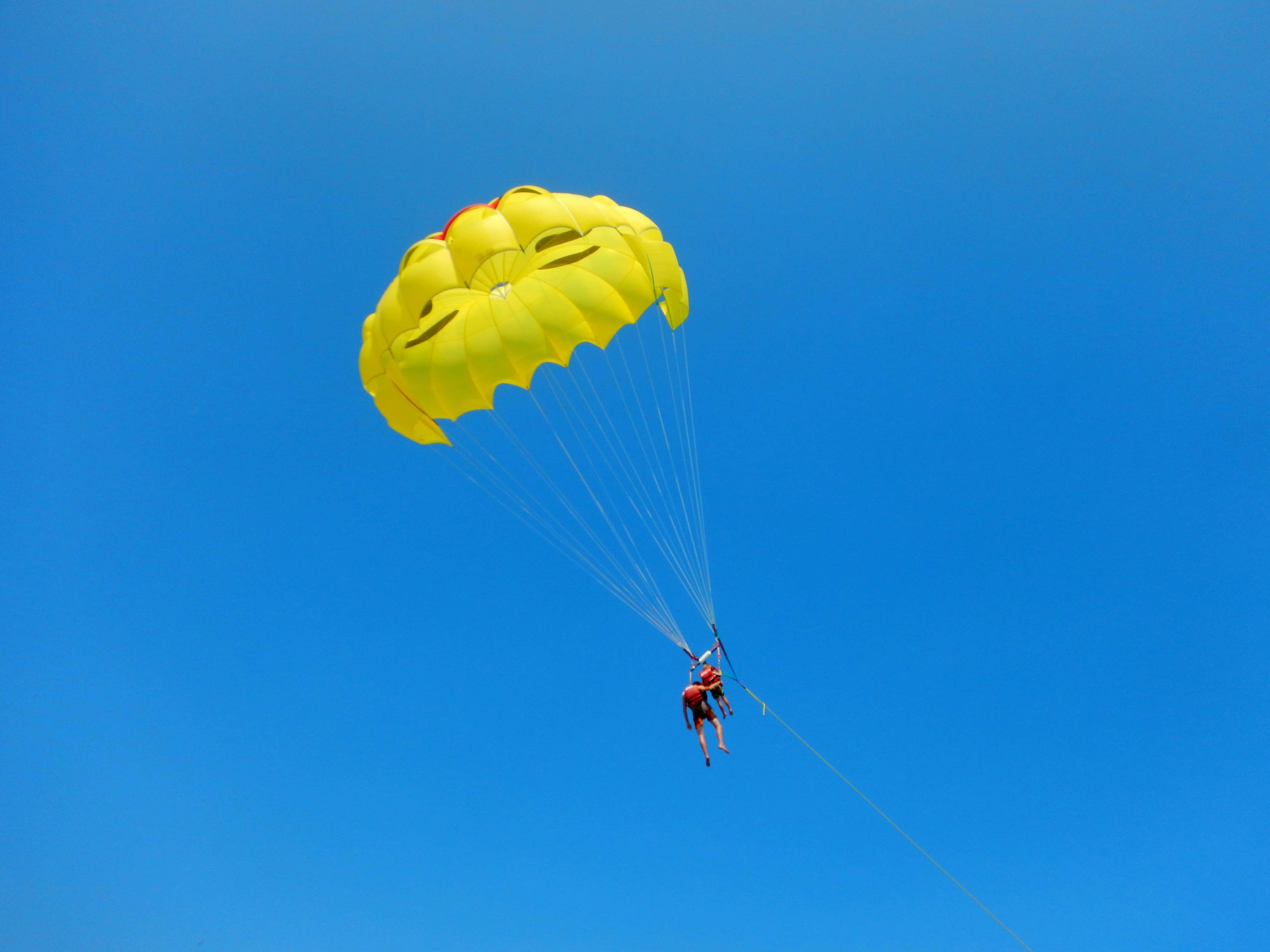 bright yellow parasail, smiling face design, clear blue sky, 4K Desktop Wallpaper