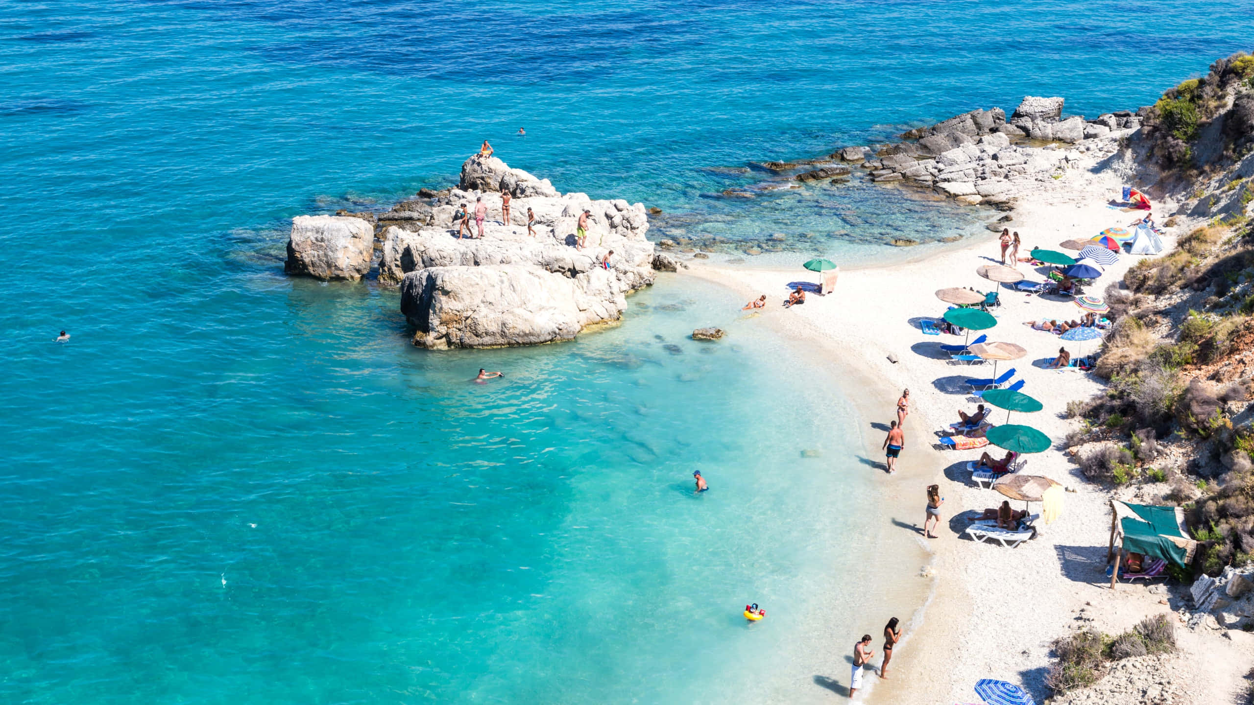 vibrant turquoise cove, white sand beach, sunbathers, 2K Desktop Wallpaper