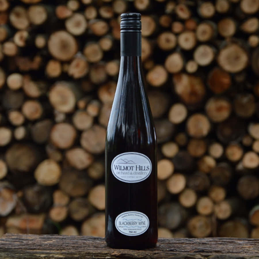 Wilmot Hills blackberry wine, dark glass bottle, rough wooden surface, SD Desktop Wallpaper