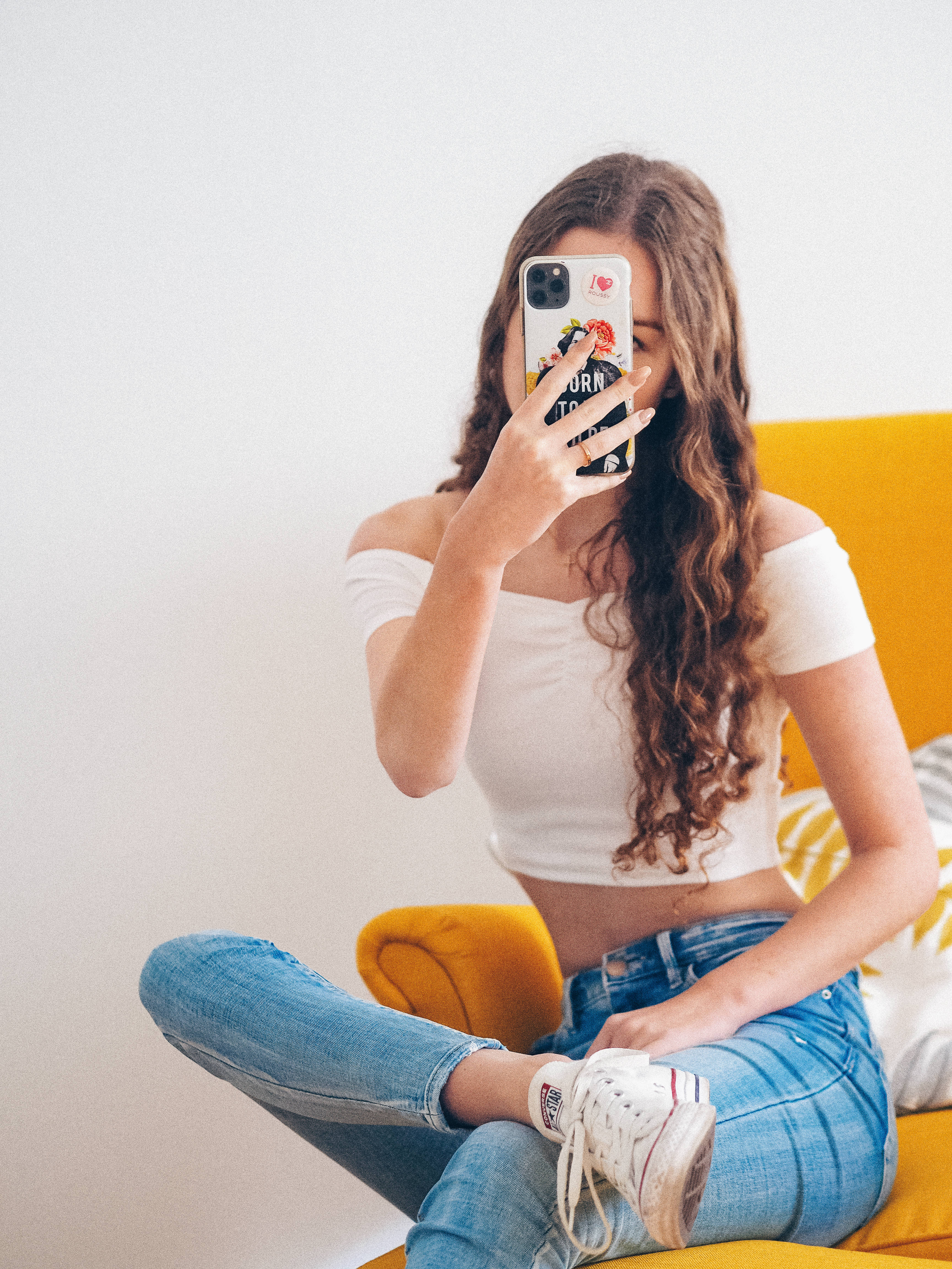 young woman, long wavy hair, bright yellow couch, 4K Phone Wallpaper