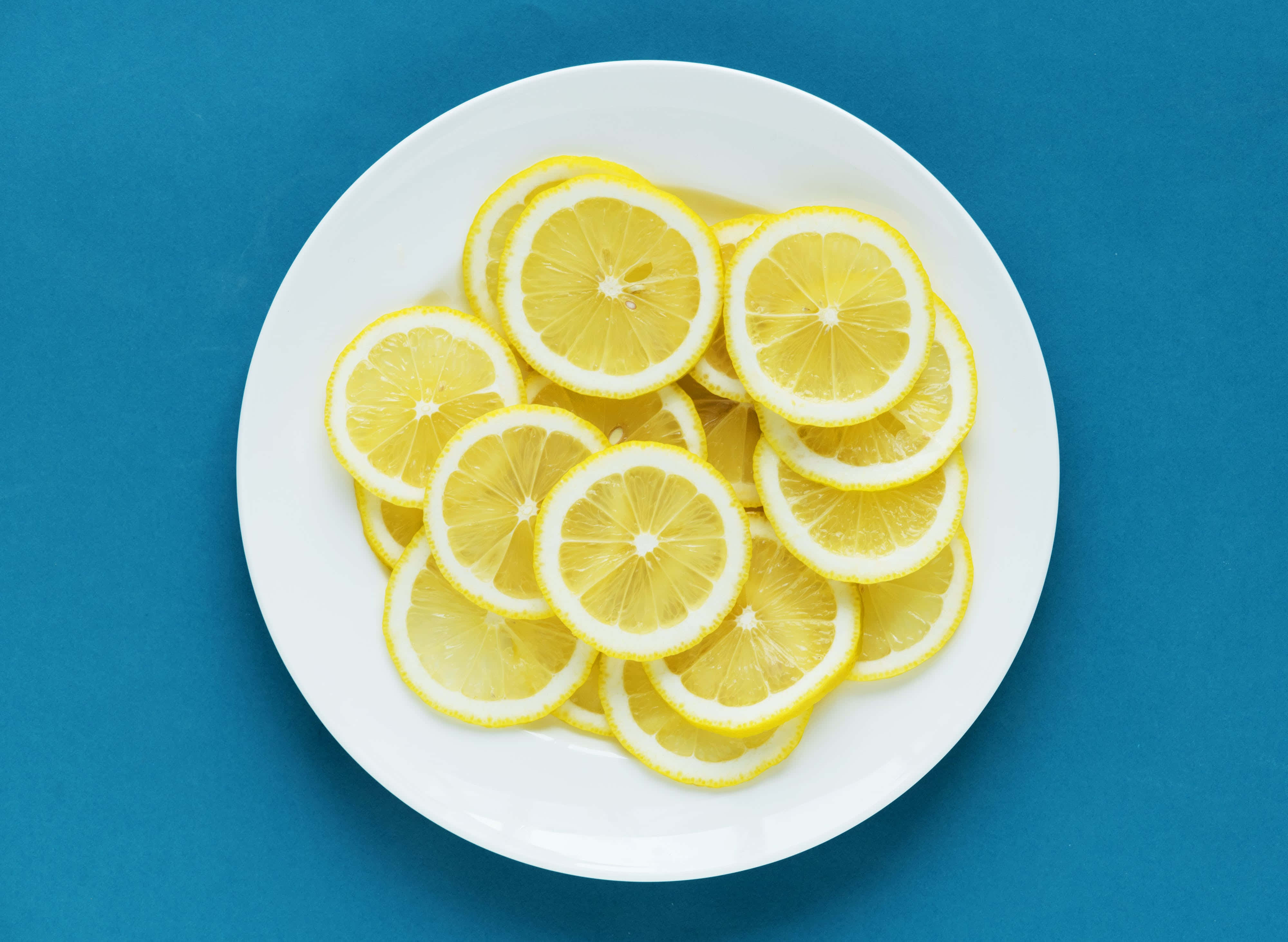 white plate, bright yellow lemon slices, vivid blue background, 4K Desktop Wallpaper