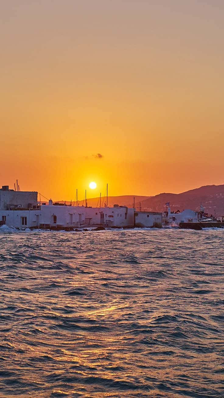 Golden sunset, white coastal buildings, rippling sea, HD Phone Wallpaper