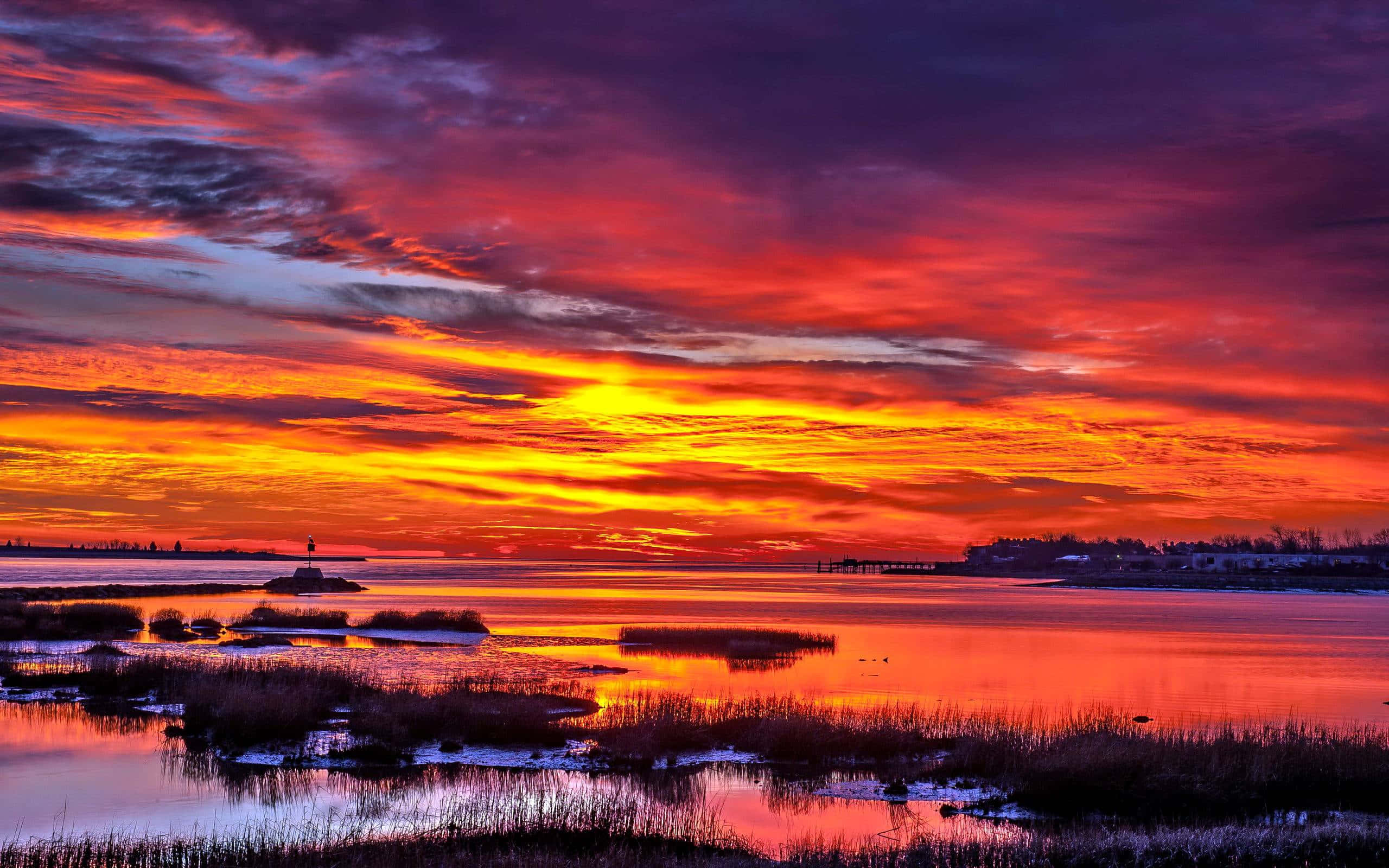 sunset landscape, fiery reds oranges and purples, calm water surface, 2K Desktop Wallpaper