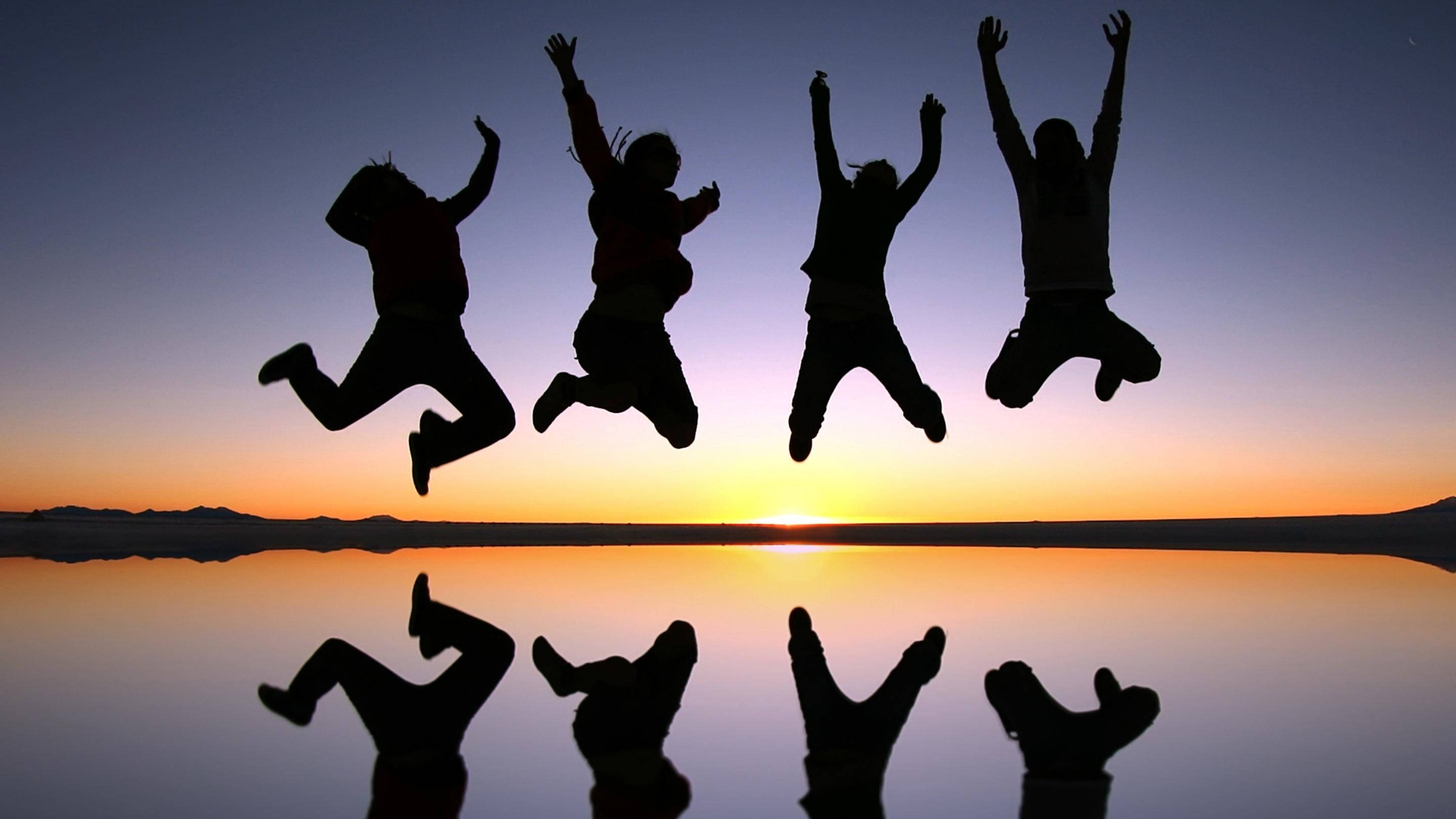 Excited Group Jumpshot, four joyful silhouettes, calm lake, 2K Desktop Wallpaper