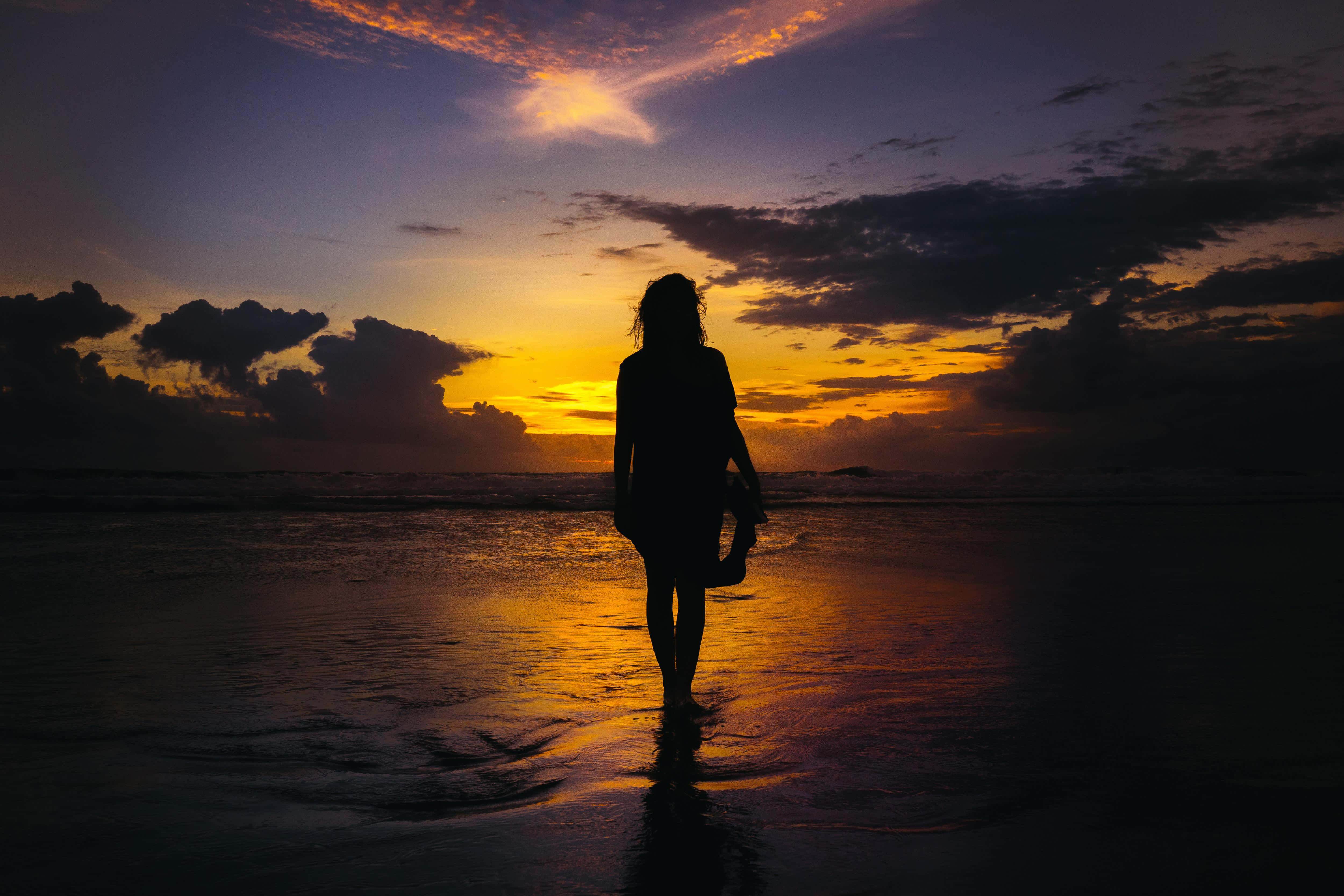 sunset silhouette, vibrant orange and purple sky, wet sand, 4K Desktop Wallpaper