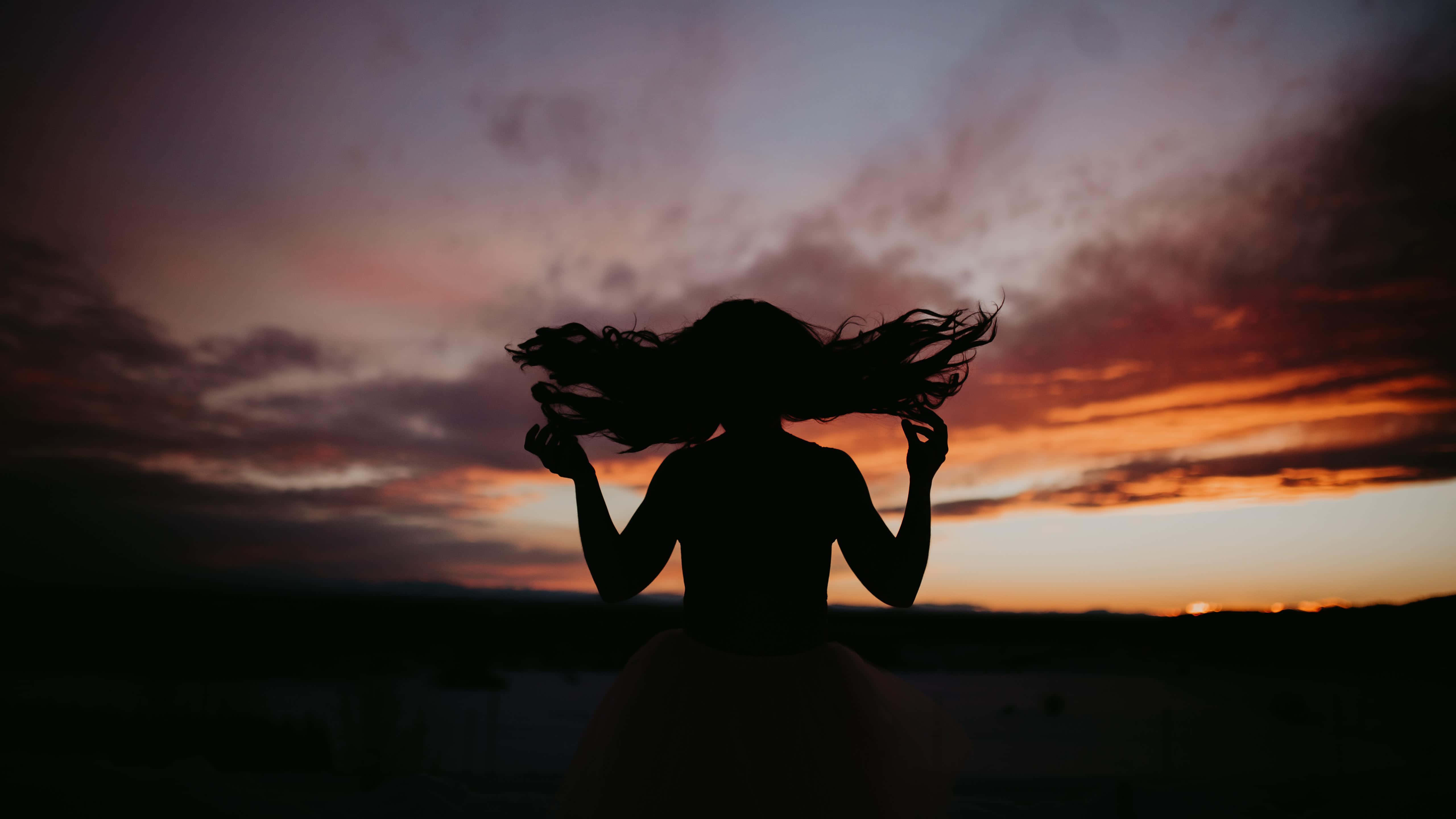 Sunset Silhouette, woman with flowing hair, vibrant sunset sky, 5K Desktop Wallpaper