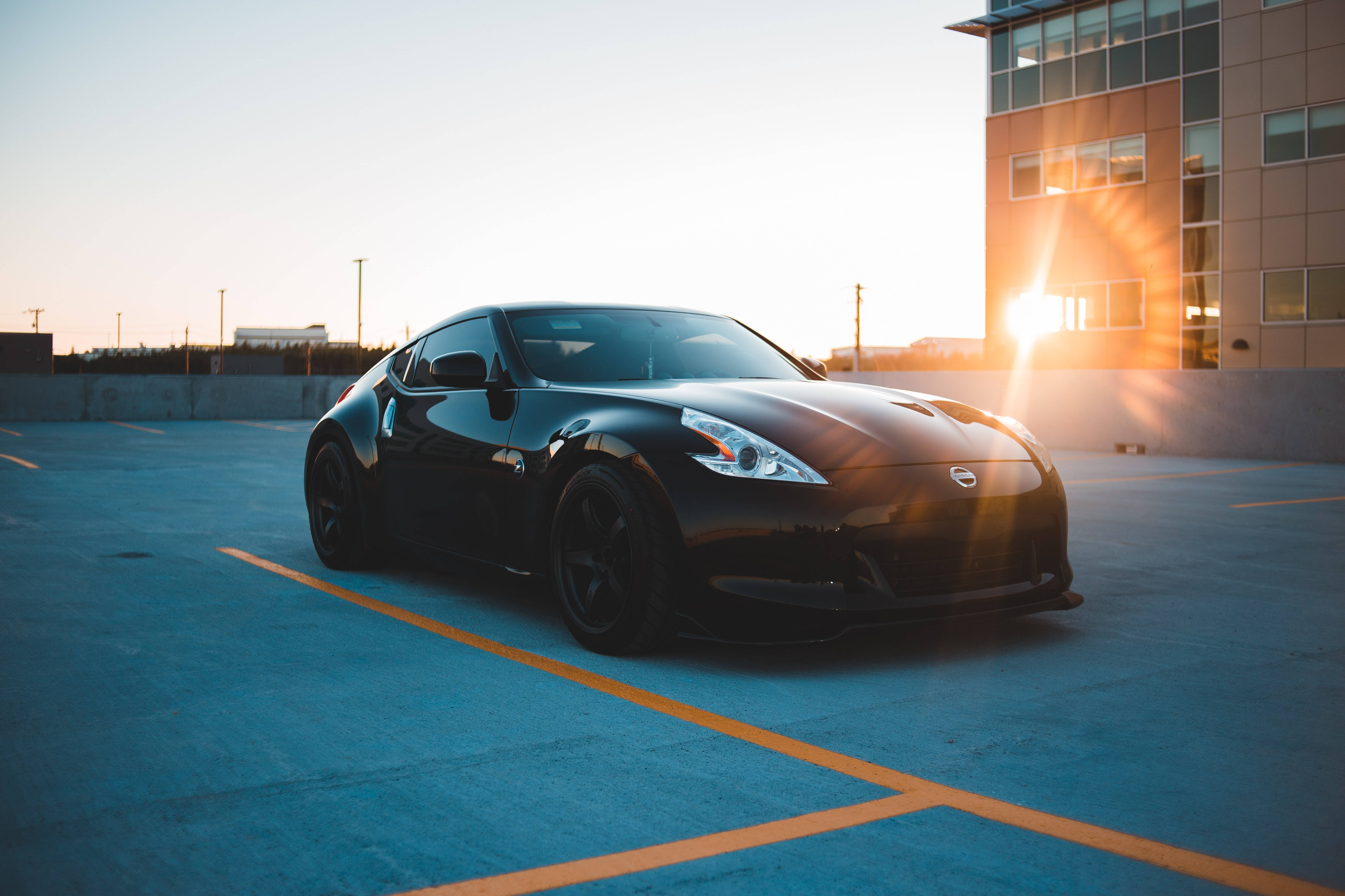 black sports cars, golden hour glow, sunlit parking lot, 5K Desktop Wallpaper
