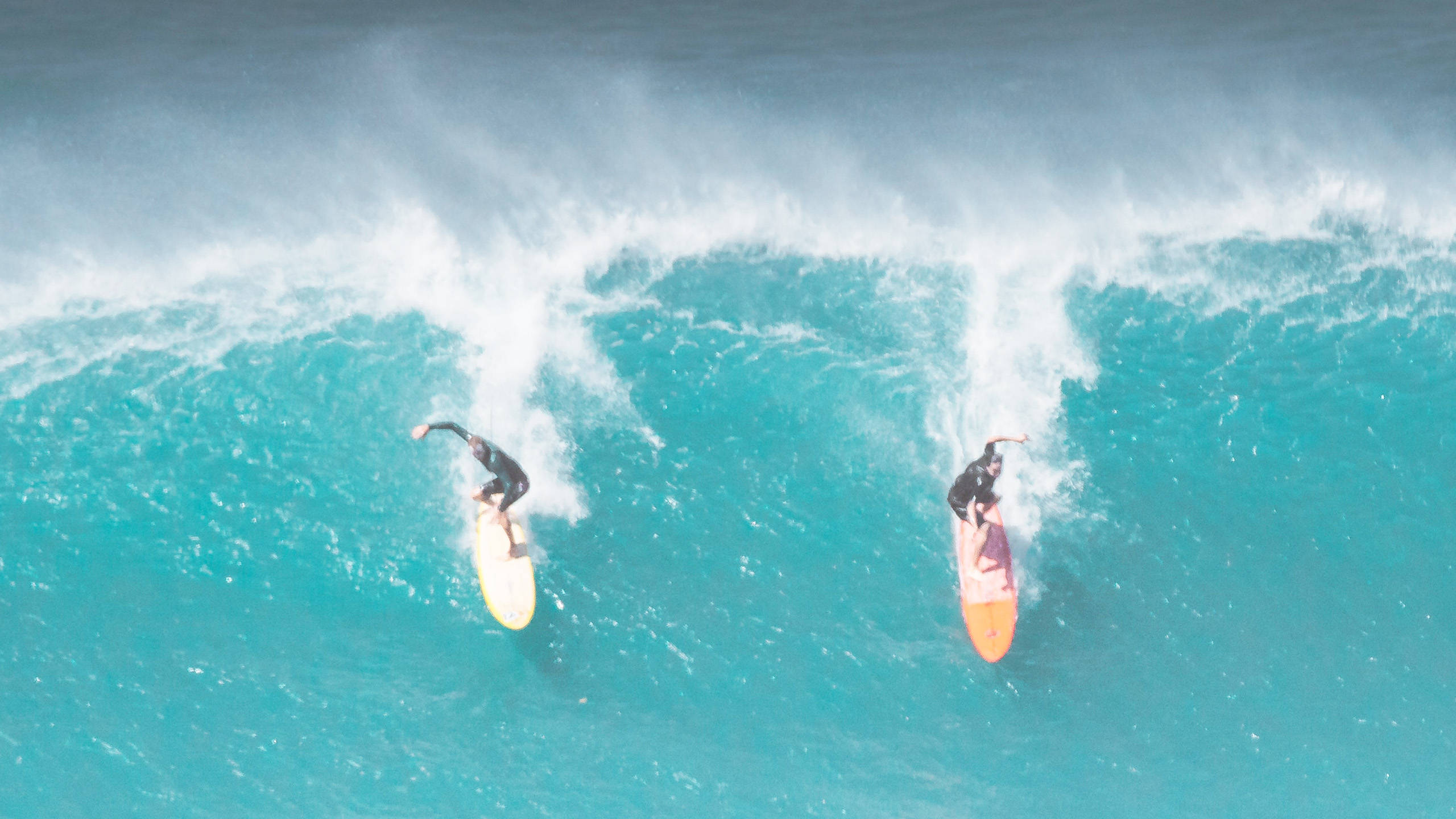 two people surfing side by side, turquoise ocean waves, aerial view, 2K Desktop Wallpaper