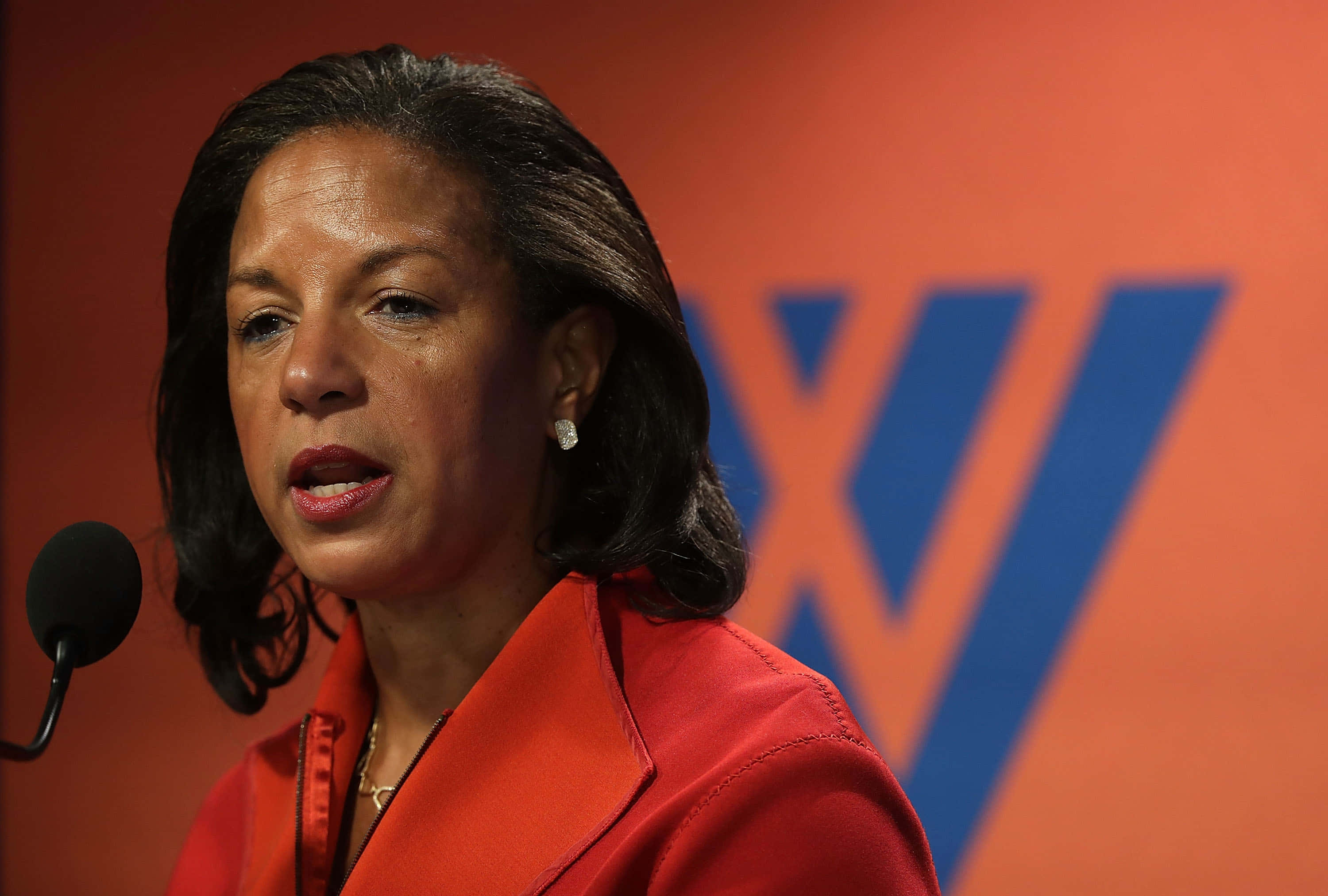 Susan Rice, red blazer, orange and blue branded backdrop, 2K Desktop Wallpaper