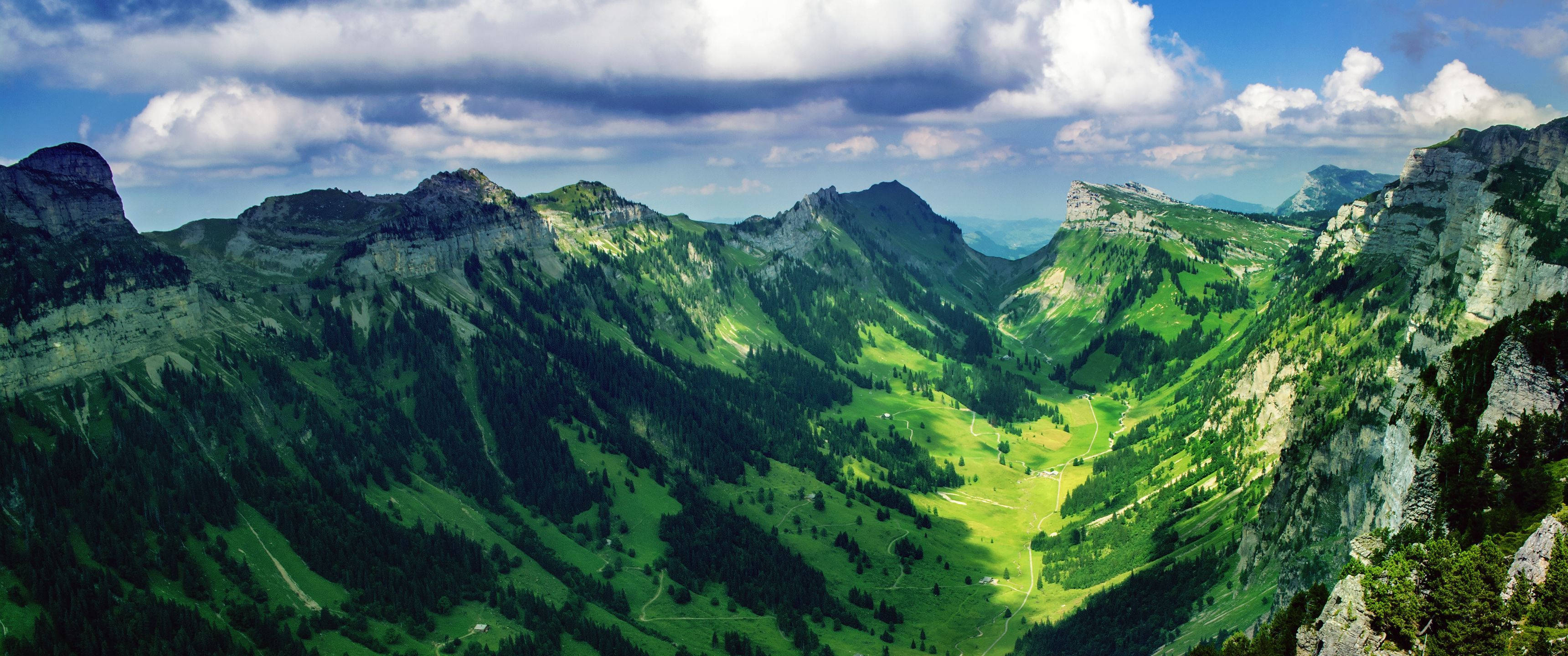scenic valley landscape, lush green valleys, rugged mountain peaks, 2K Desktop Wallpaper