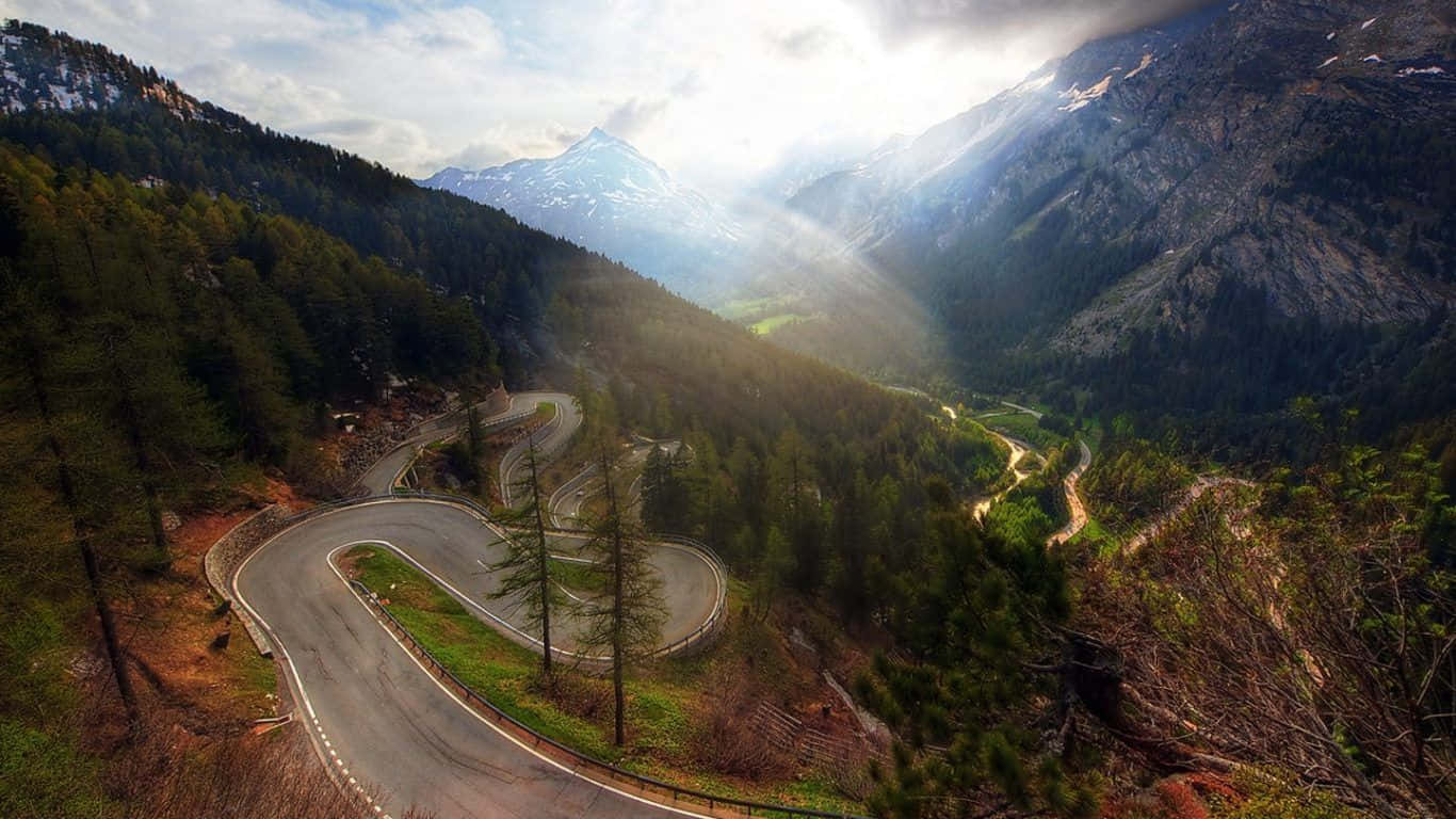 winding mountain road, dense forests, snow-capped peaks, HD Desktop Wallpaper