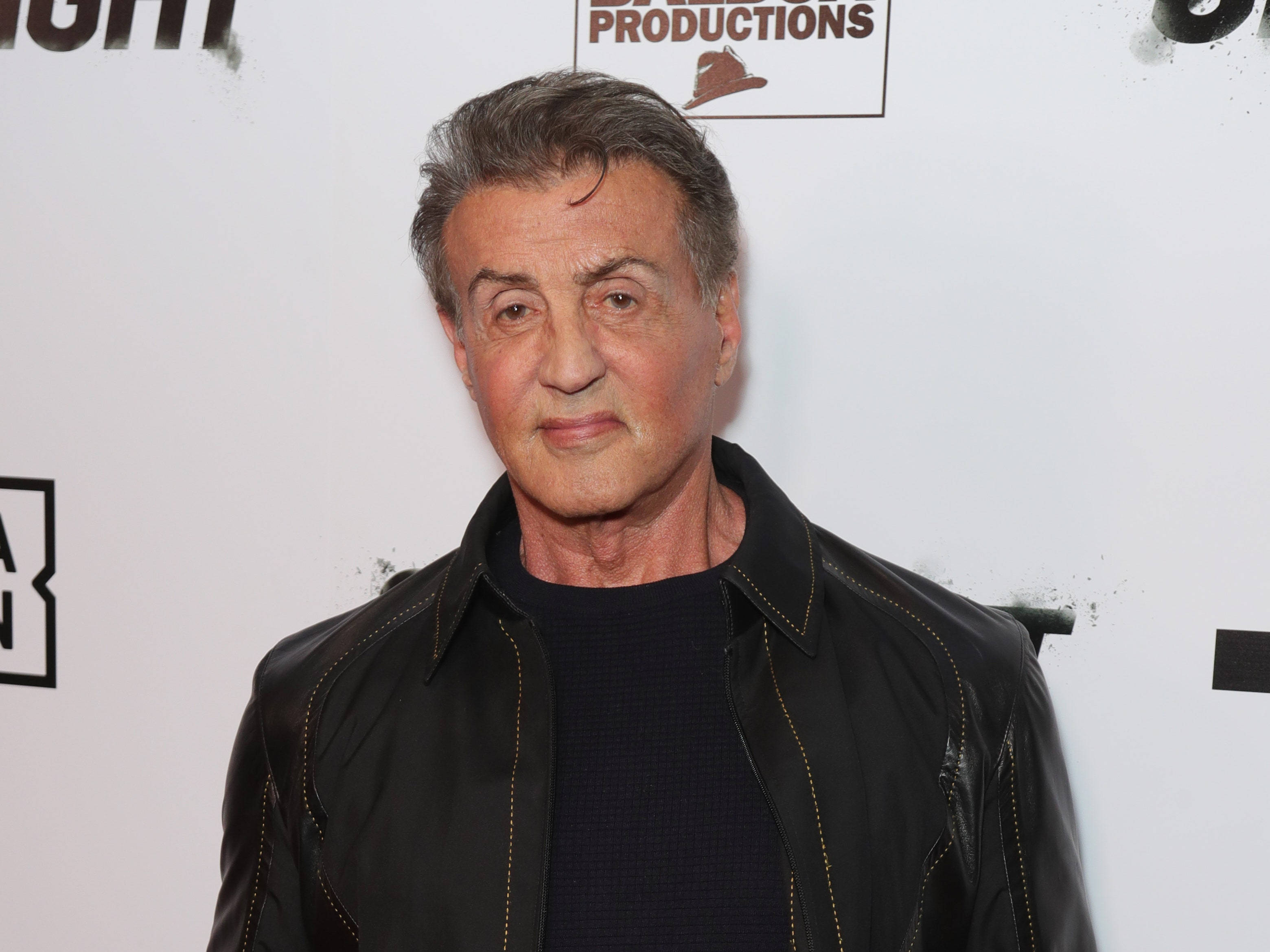 Sylvester Stallone, black leather jacket, branded backdrop, 2K Desktop Wallpaper